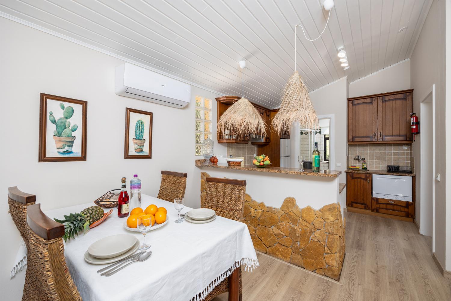 Open-plan living room with sofa, dining area, kitchen, A/C, WiFi internet, and satellite TV
