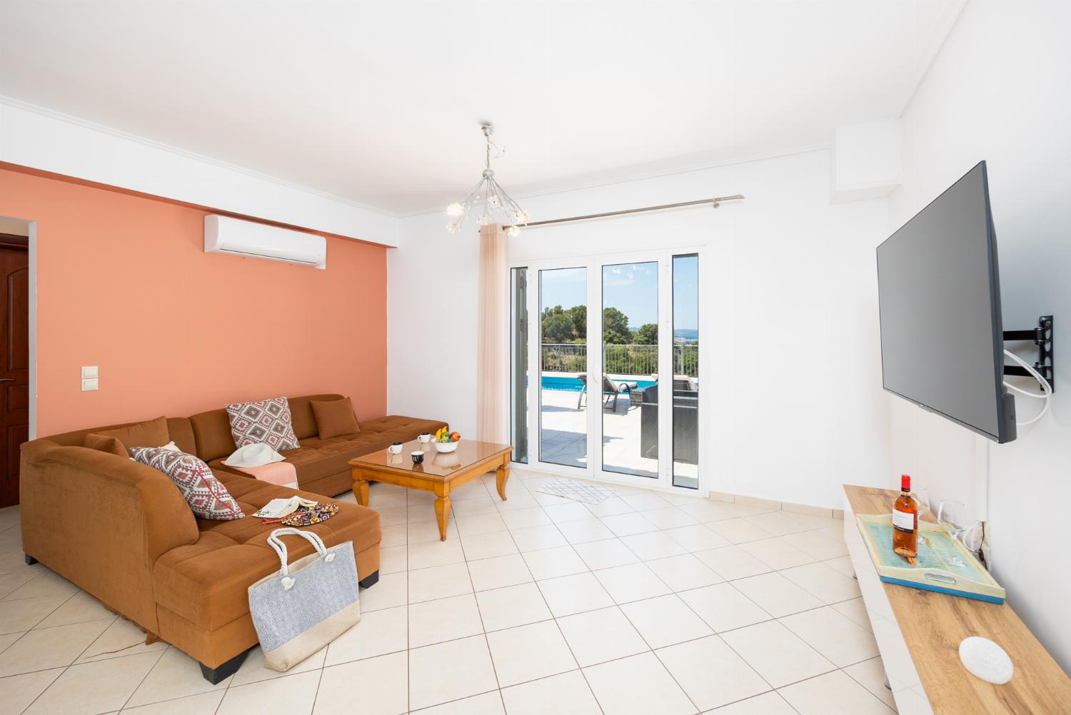 Open-plan living room with sofa, dining area, kitchen, A/C, WiFi internet, and satellite TV