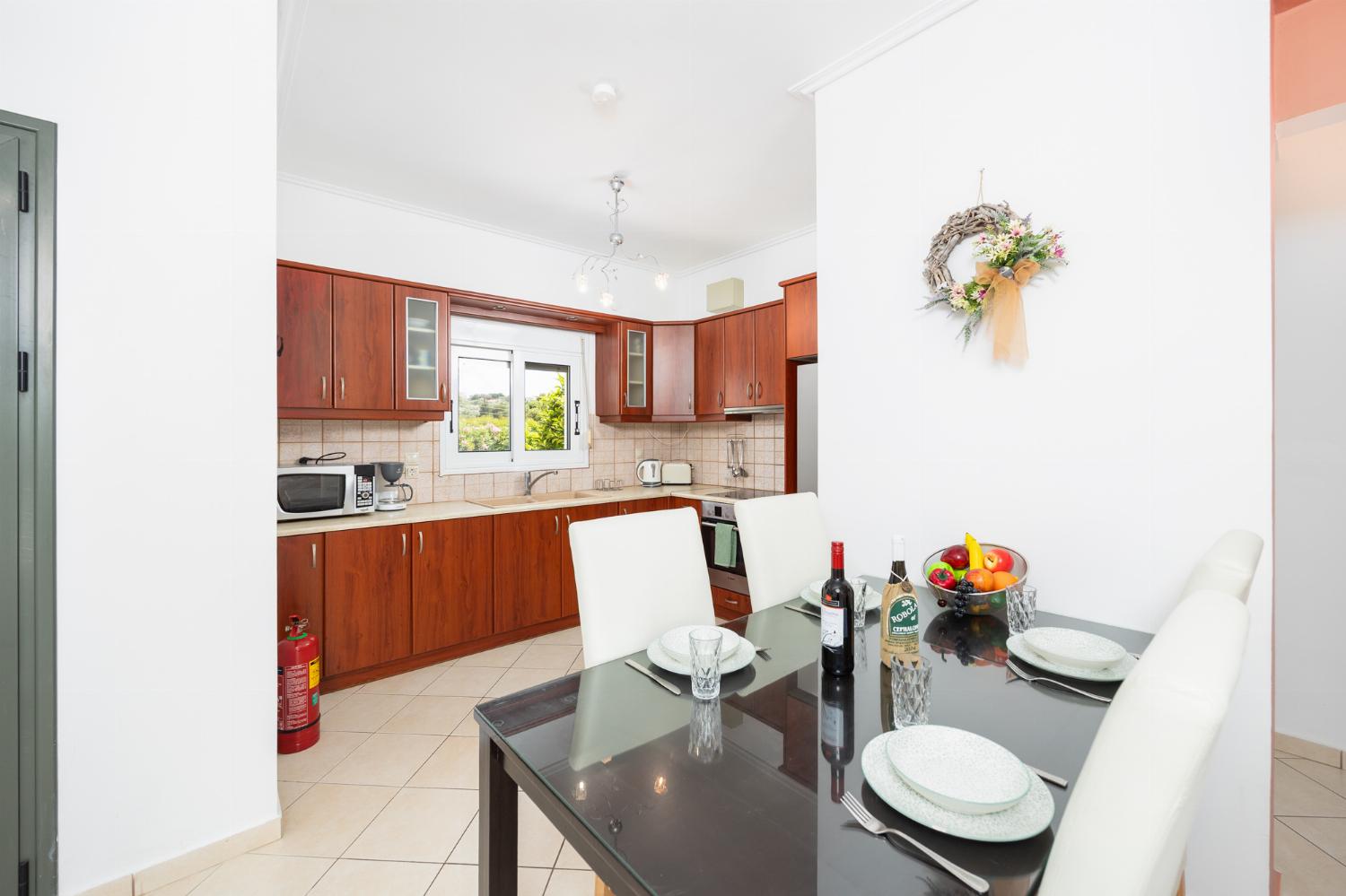 Open-plan living room with sofa, dining area, kitchen, A/C, WiFi internet, and satellite TV