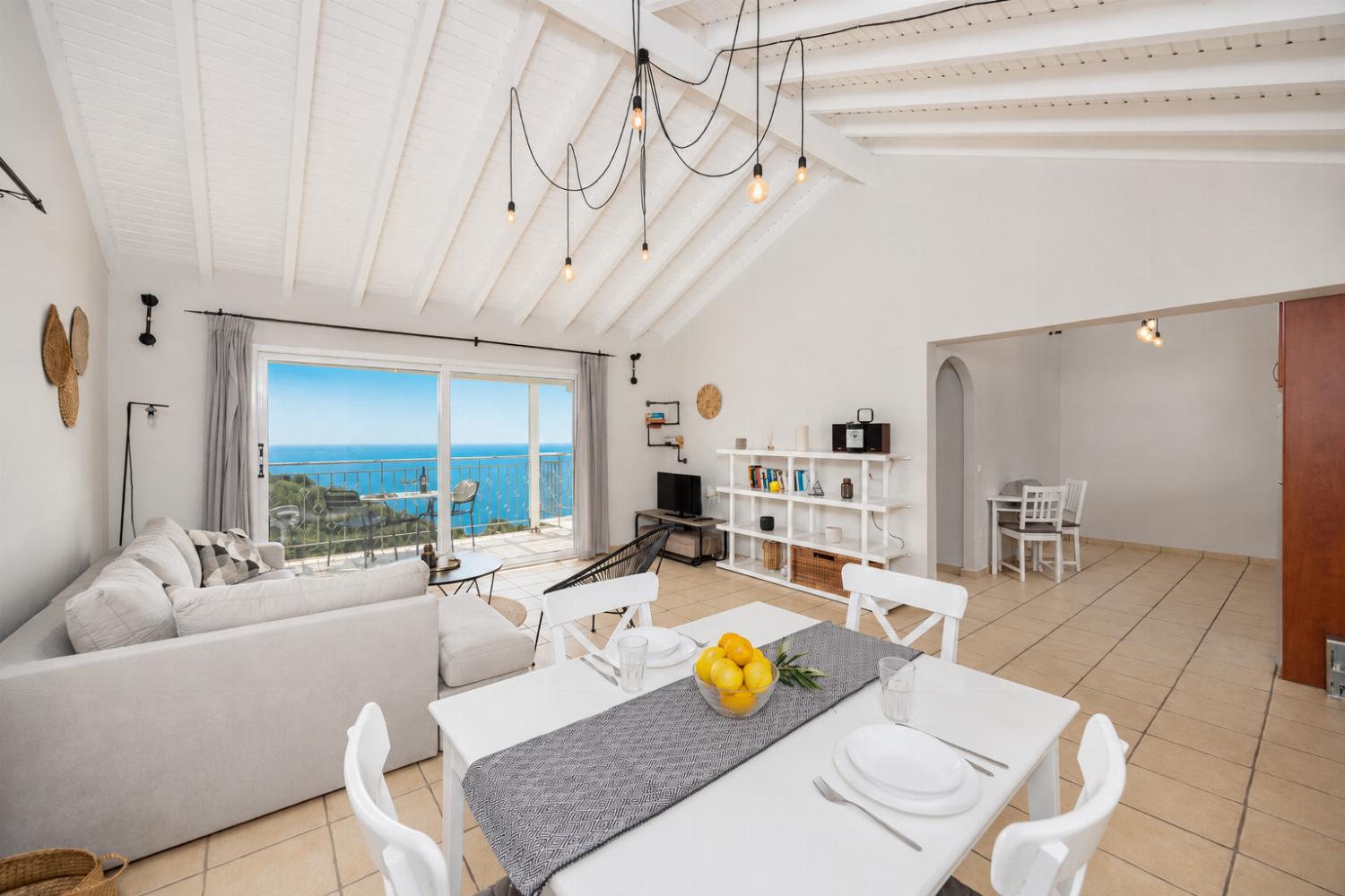 Open-plan living room with sofa, dining area, kitchen, A/C, WiFi internet, satellite TV, and sea views