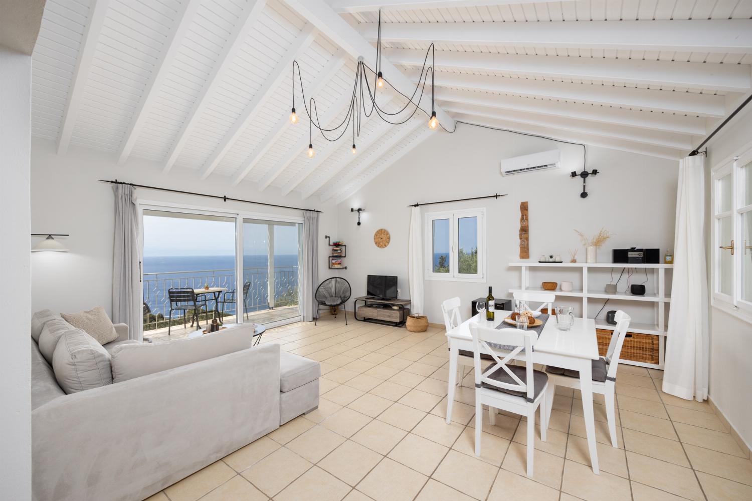 Open-plan living room with sofa, dining area, kitchen, A/C, WiFi internet, satellite TV, and sea views