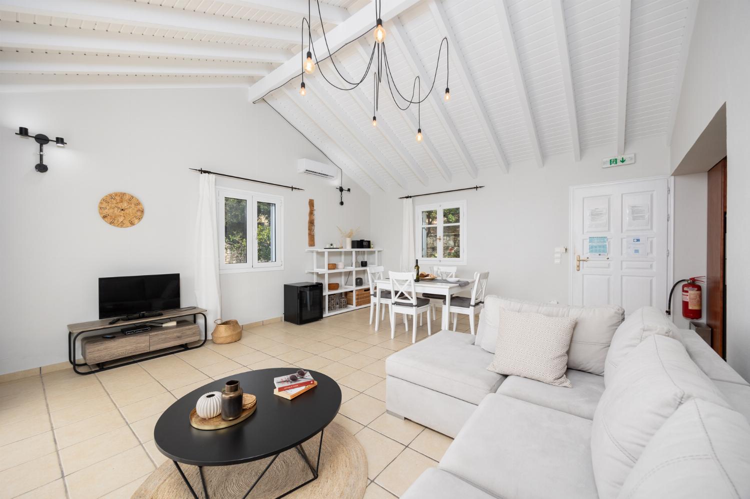 Open-plan living room with sofa, dining area, kitchen, A/C, WiFi internet, satellite TV, and sea views