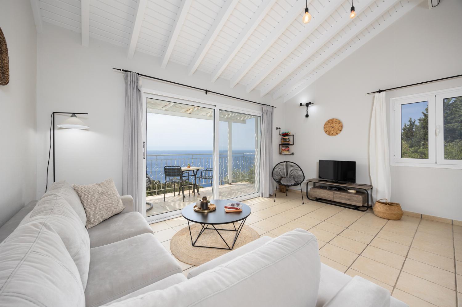 Open-plan living room with sofa, dining area, kitchen, A/C, WiFi internet, satellite TV, and sea views