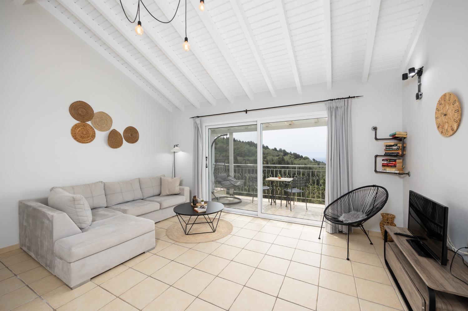 Open-plan living room with sofa, dining area, kitchen, A/C, WiFi internet, satellite TV, and sea views