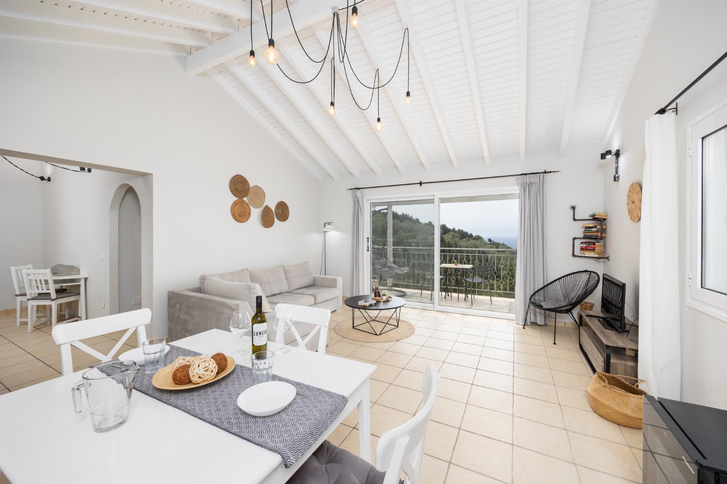 Open-plan living room with sofa, dining area, kitchen, A/C, WiFi internet, satellite TV, and sea views