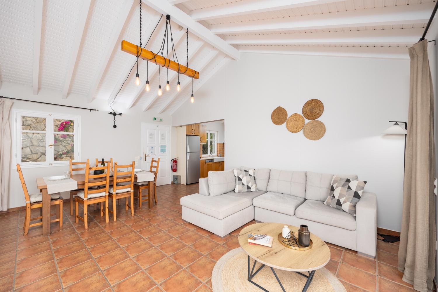 Open-plan living room with sofa, dining area, kitchen, ornamental fireplace, A/C, WiFi internet, satellite TV, and sea views