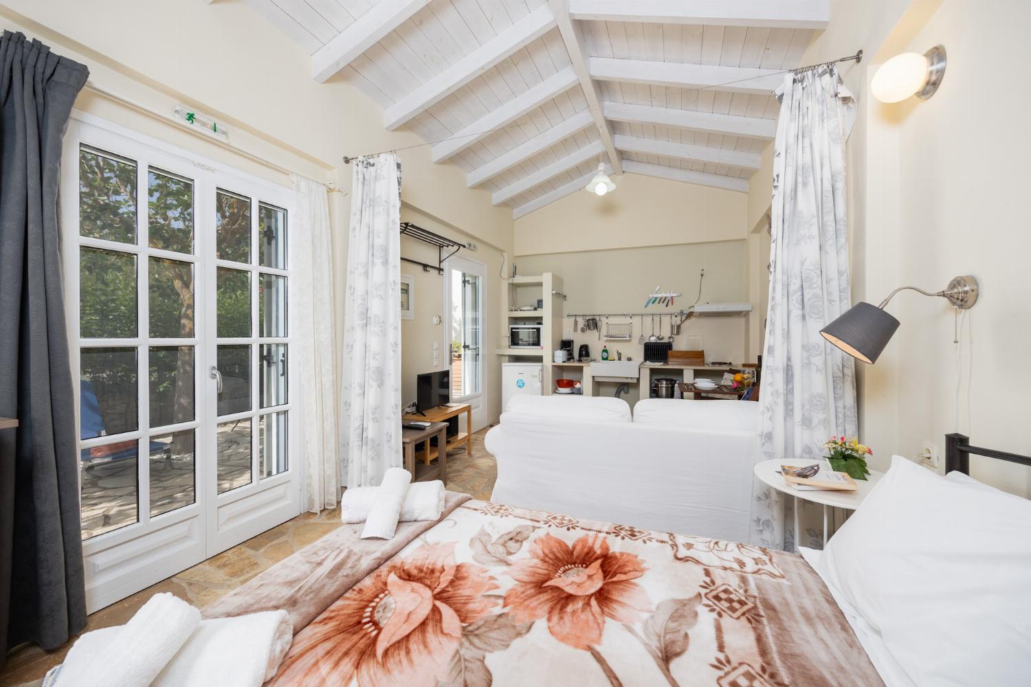 Open-plan cottage with double bed, sofa, dining area, kitchen, bathroom, A/C, WiFi internet, and TV