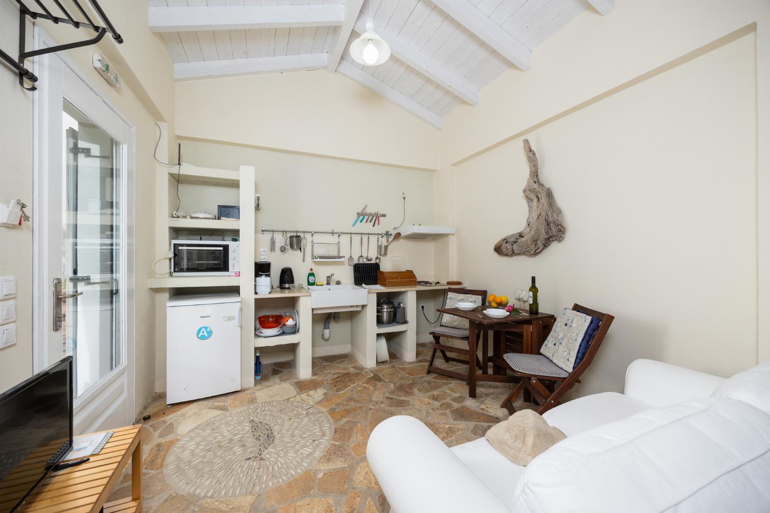 Open-plan cottage with double bed, sofa, dining area, kitchen, bathroom, A/C, WiFi internet, and TV