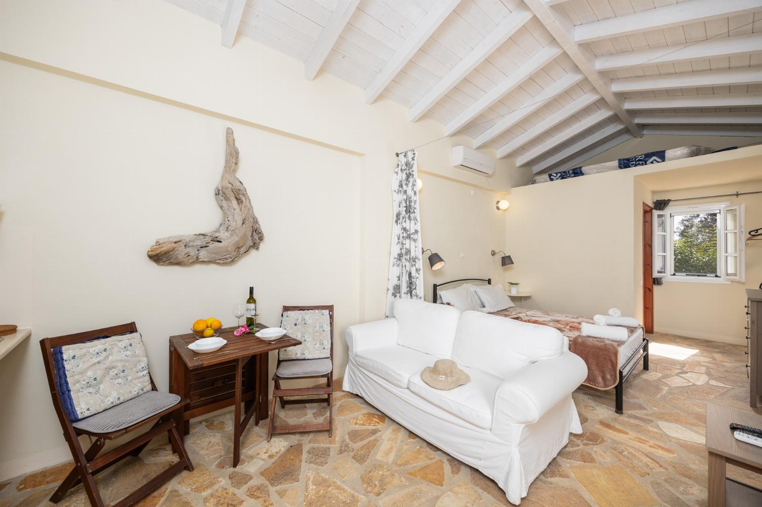 Open-plan cottage with double bed, sofa, dining area, kitchen, bathroom, A/C, WiFi internet, and TV