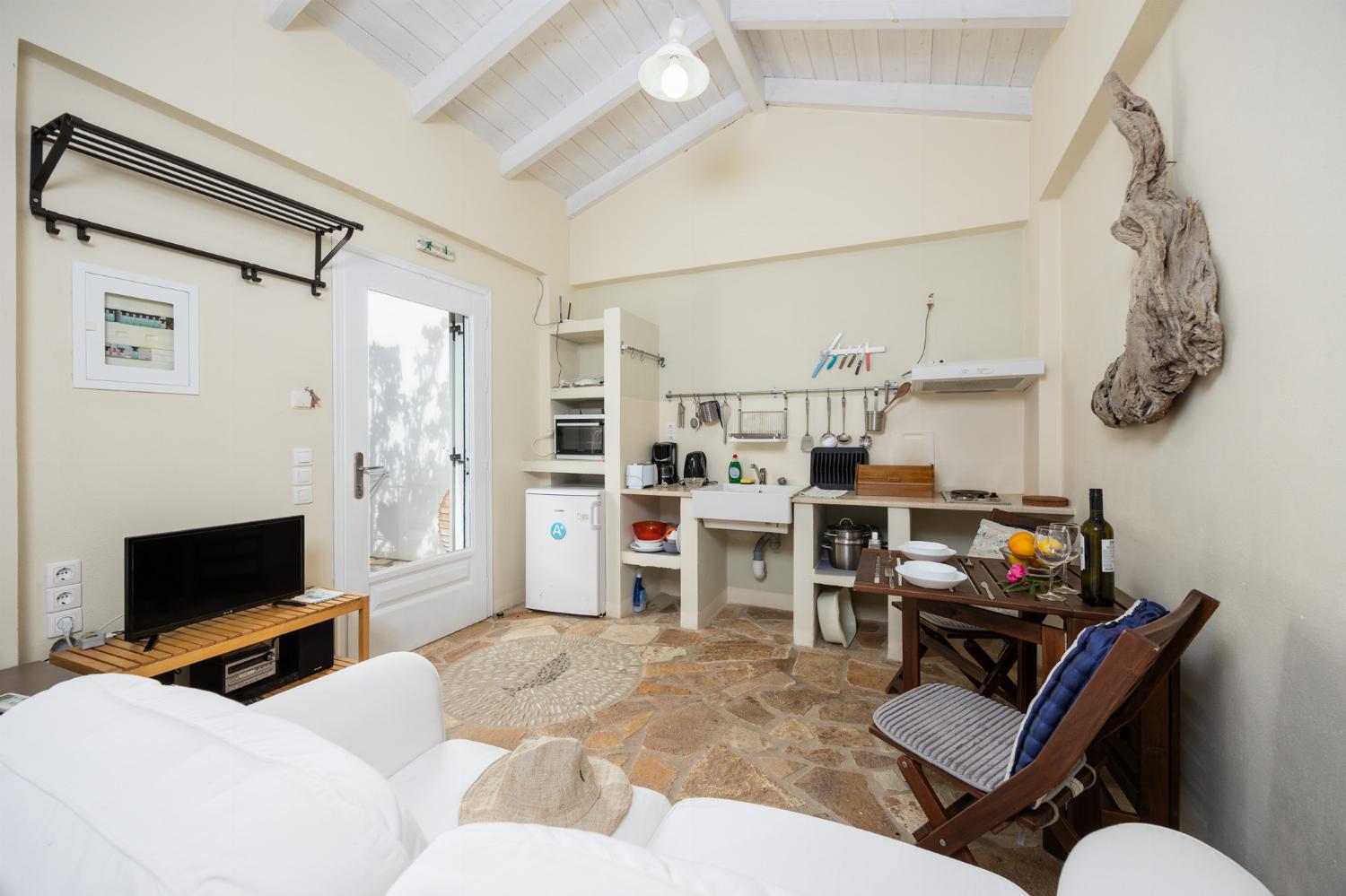 Open-plan cottage with double bed, sofa, dining area, kitchen, bathroom, A/C, WiFi internet, and TV
