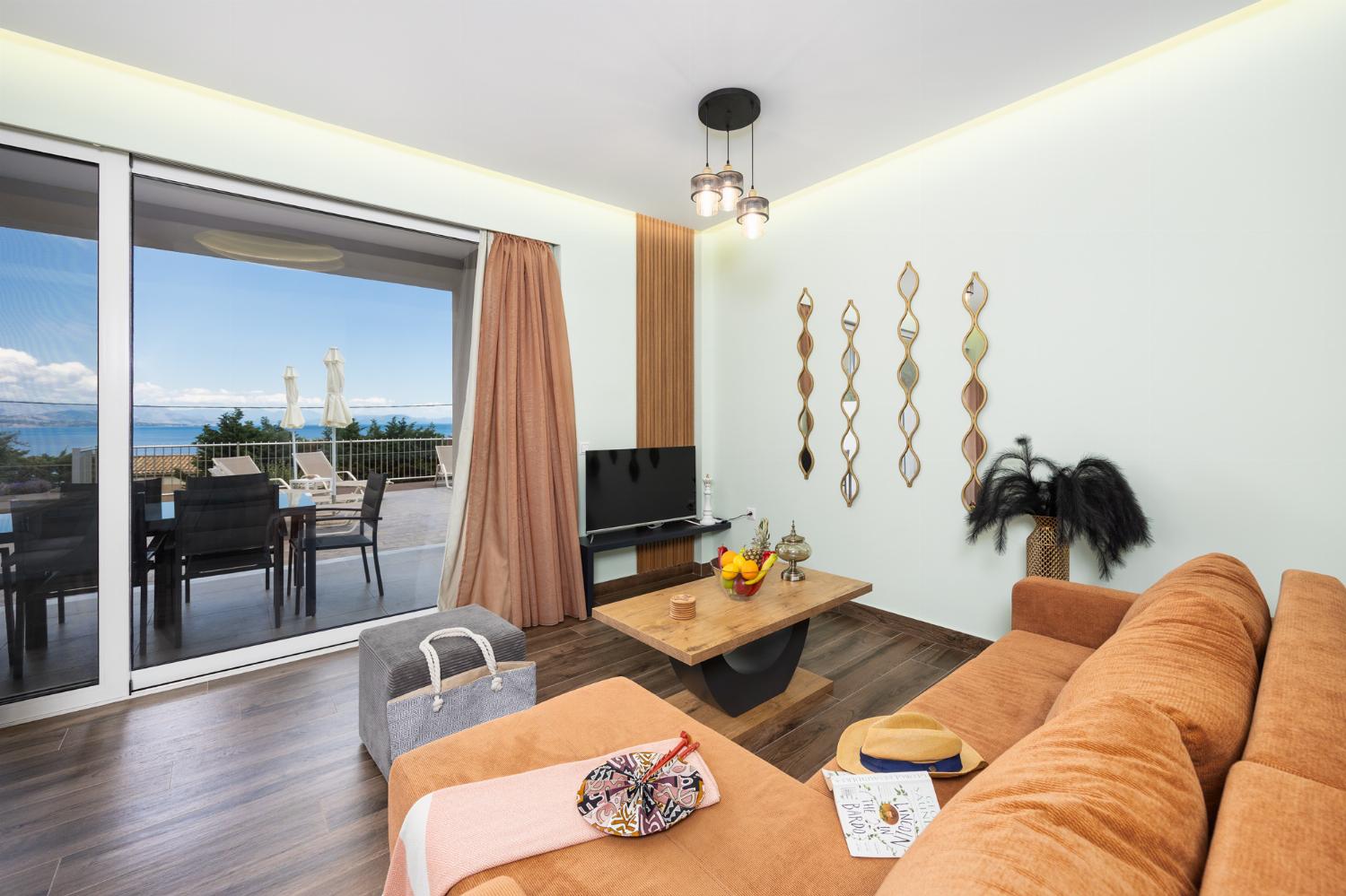 Open-plan living room with sofa, dining area, kitchen, A/C, WiFi internet, satellite TV, and sea views