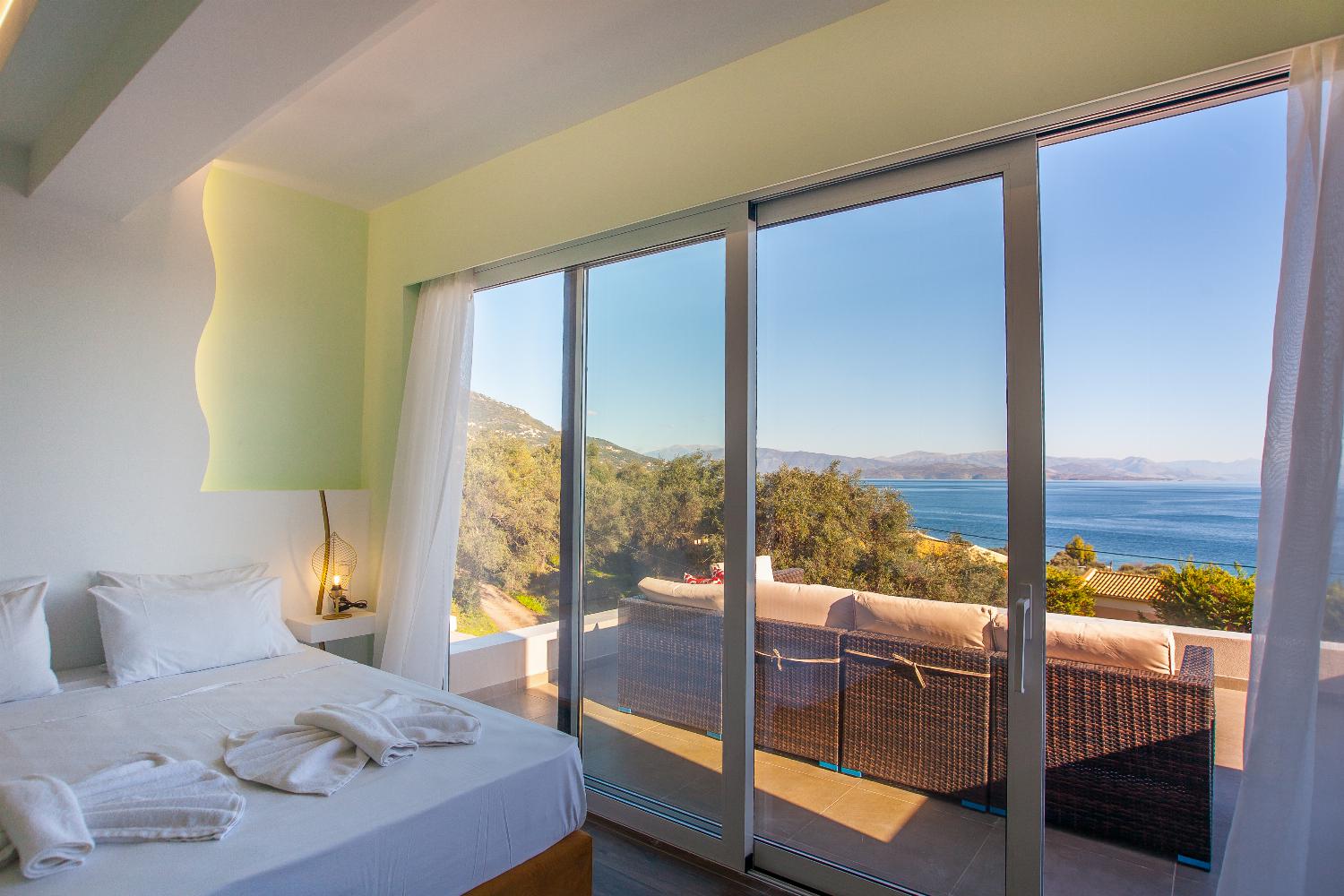 Double bedroom with en suite bathroom, A/C, and balcony access with panoramic sea views