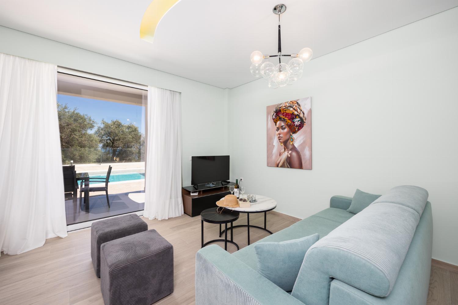 Open-plan living room with sofa, dining area, kitchen, A/C, WiFi internet, and satellite TV