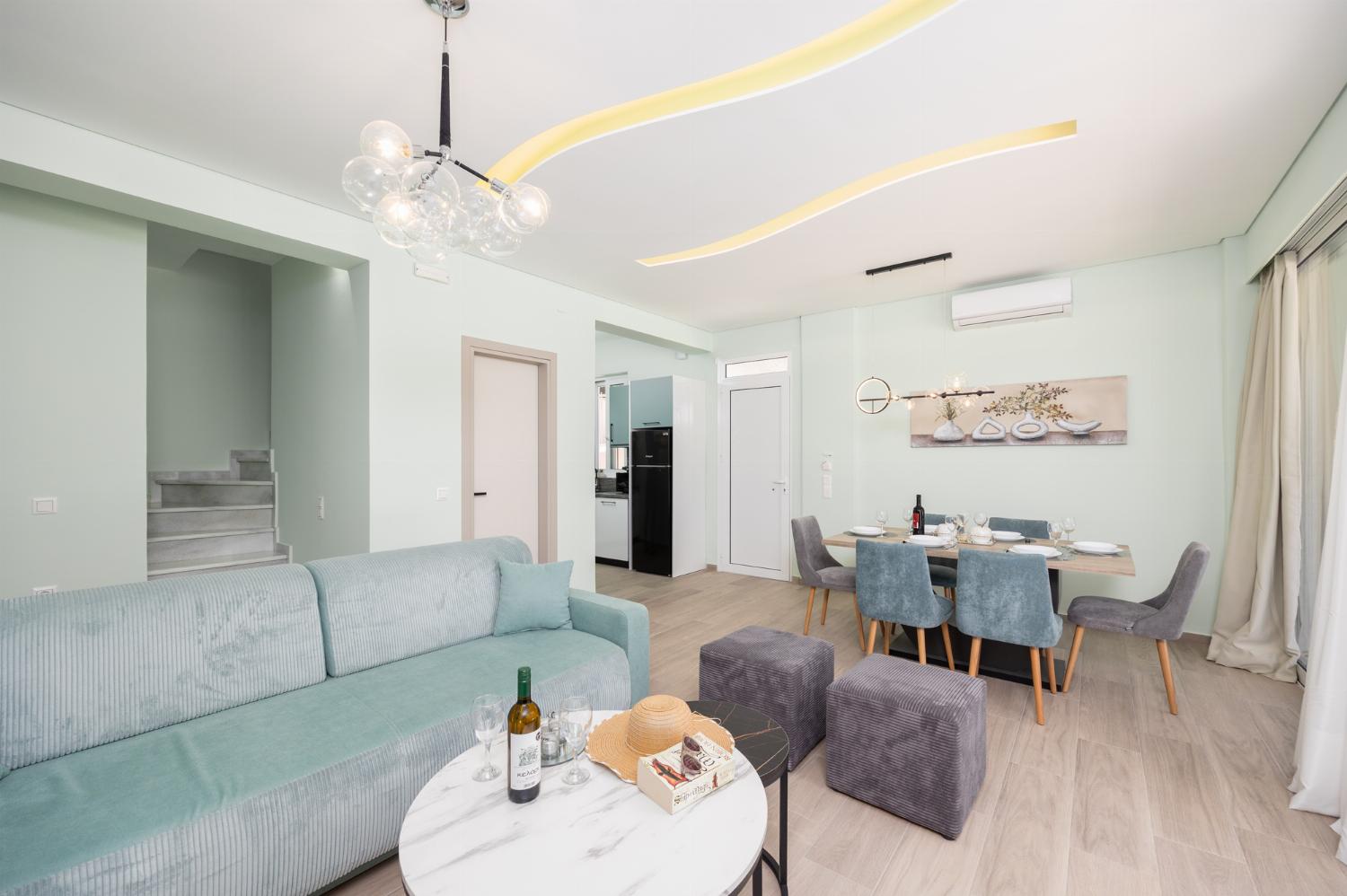 Open-plan living room with sofa, dining area, kitchen, A/C, WiFi internet, and satellite TV