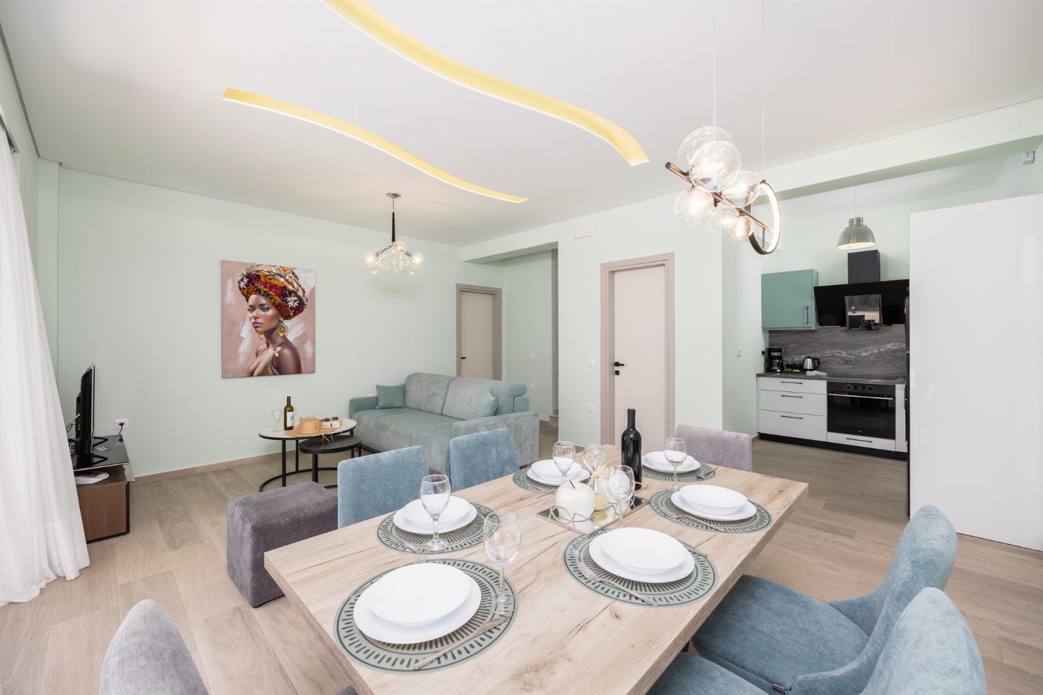 Open-plan living room with sofa, dining area, kitchen, A/C, WiFi internet, and satellite TV