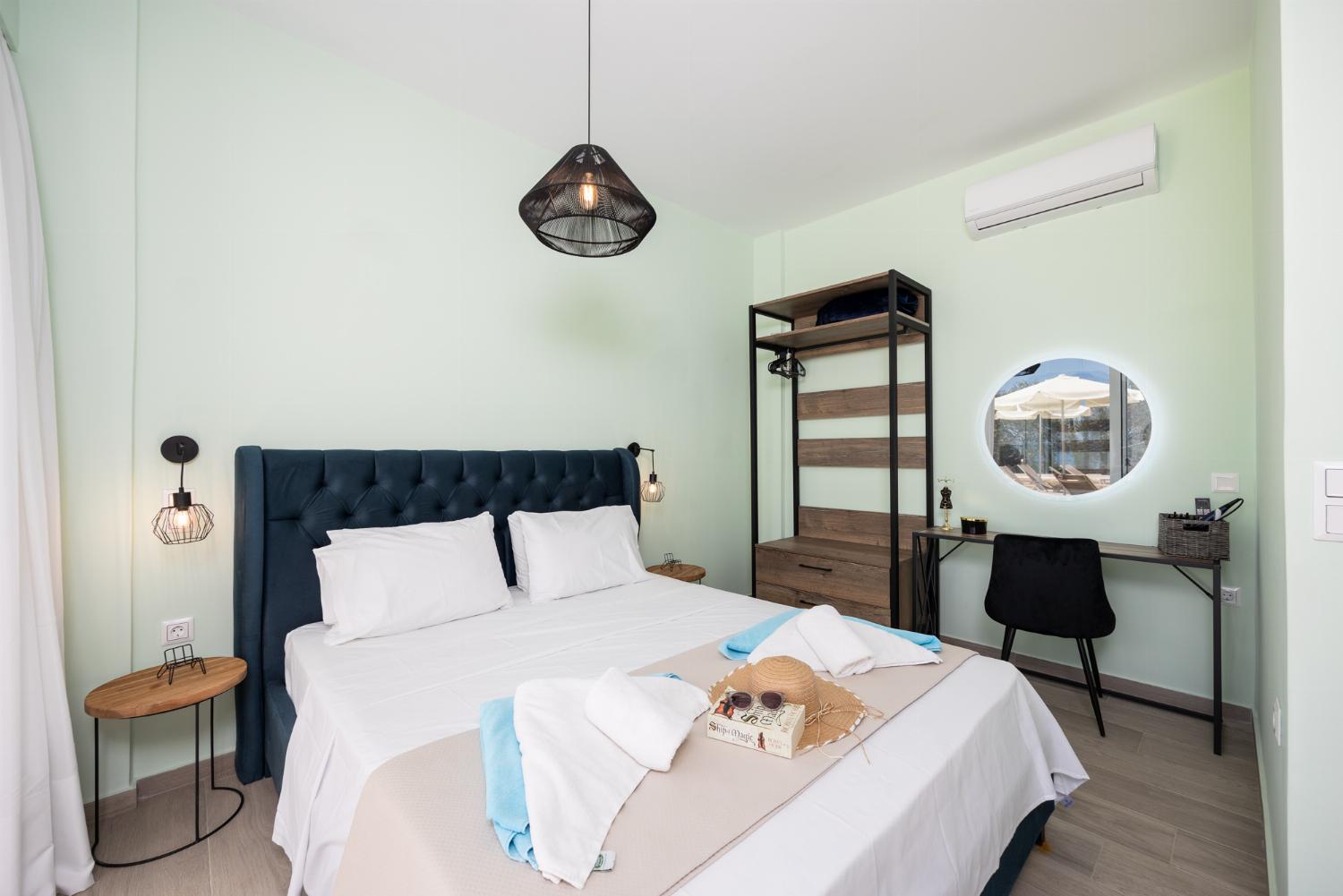 Double bedroom with en suite bathroom, A/C, and TV