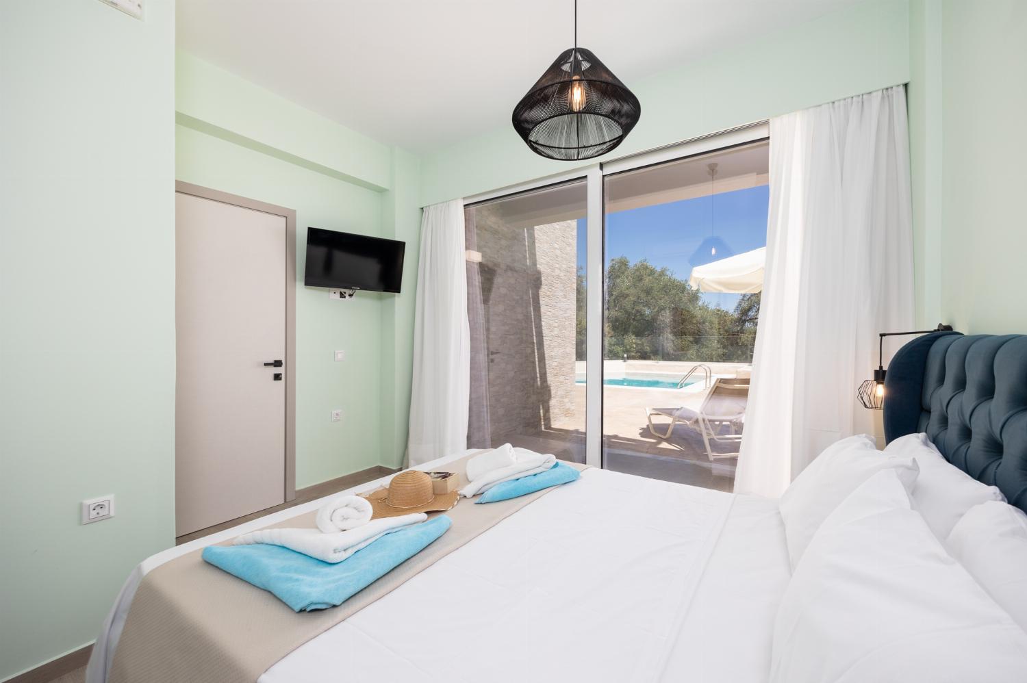 Double bedroom with en suite bathroom, A/C, and TV