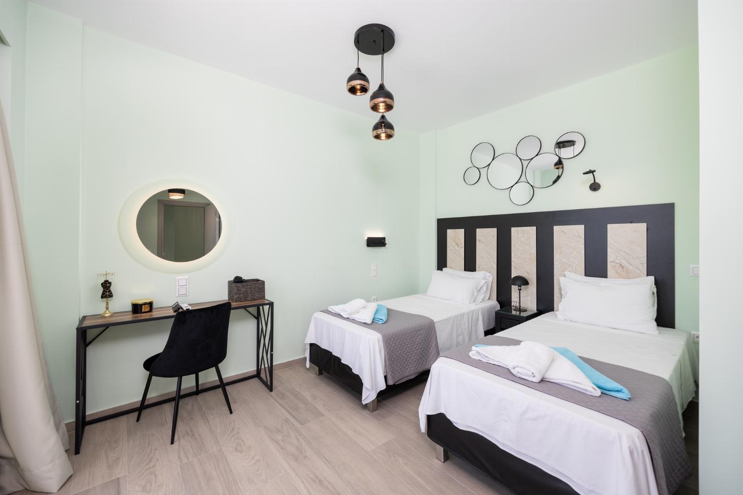 Twin bedroom with en suite bathroom, A/C, TV, and sea views