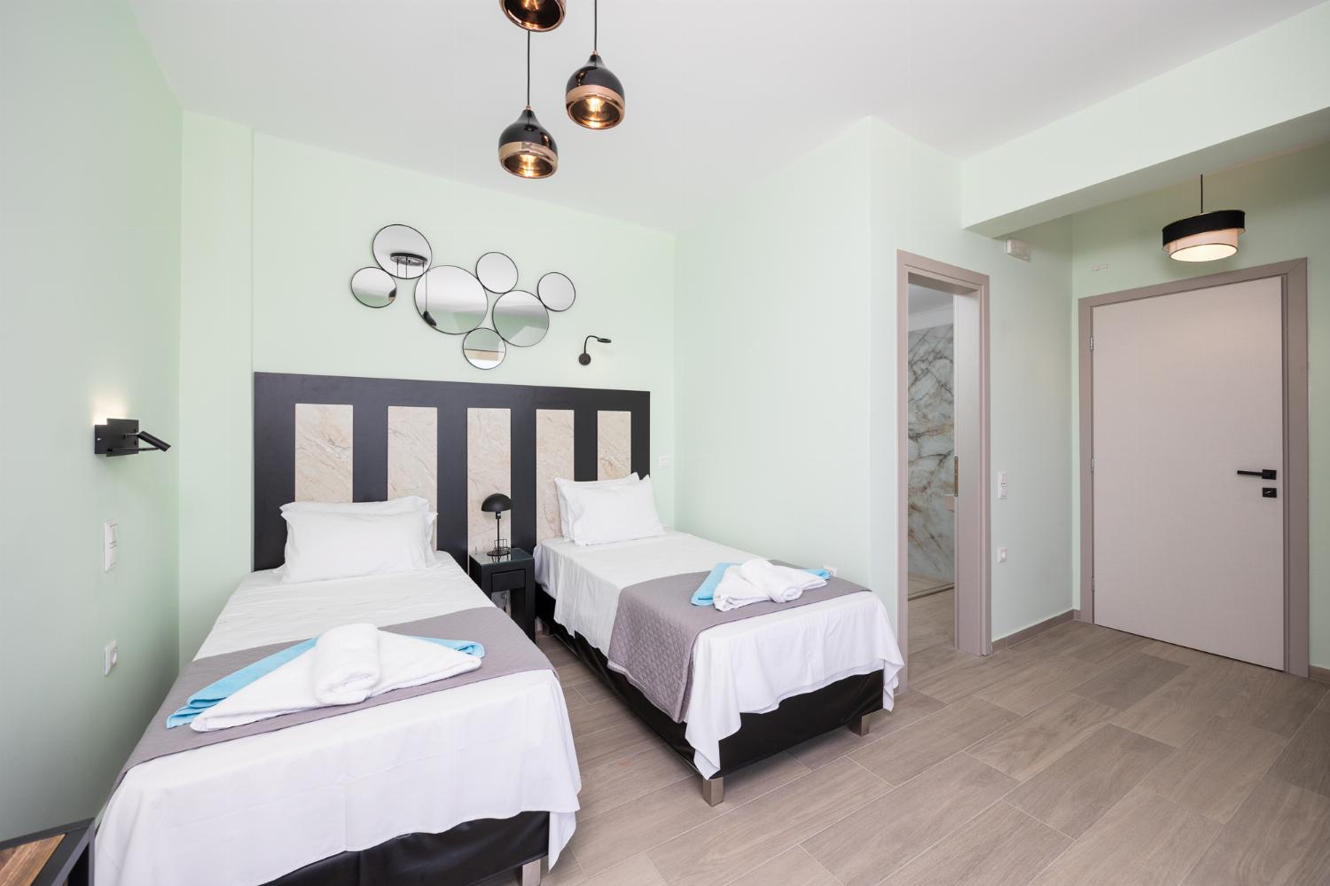Twin bedroom with en suite bathroom, A/C, TV, and sea views