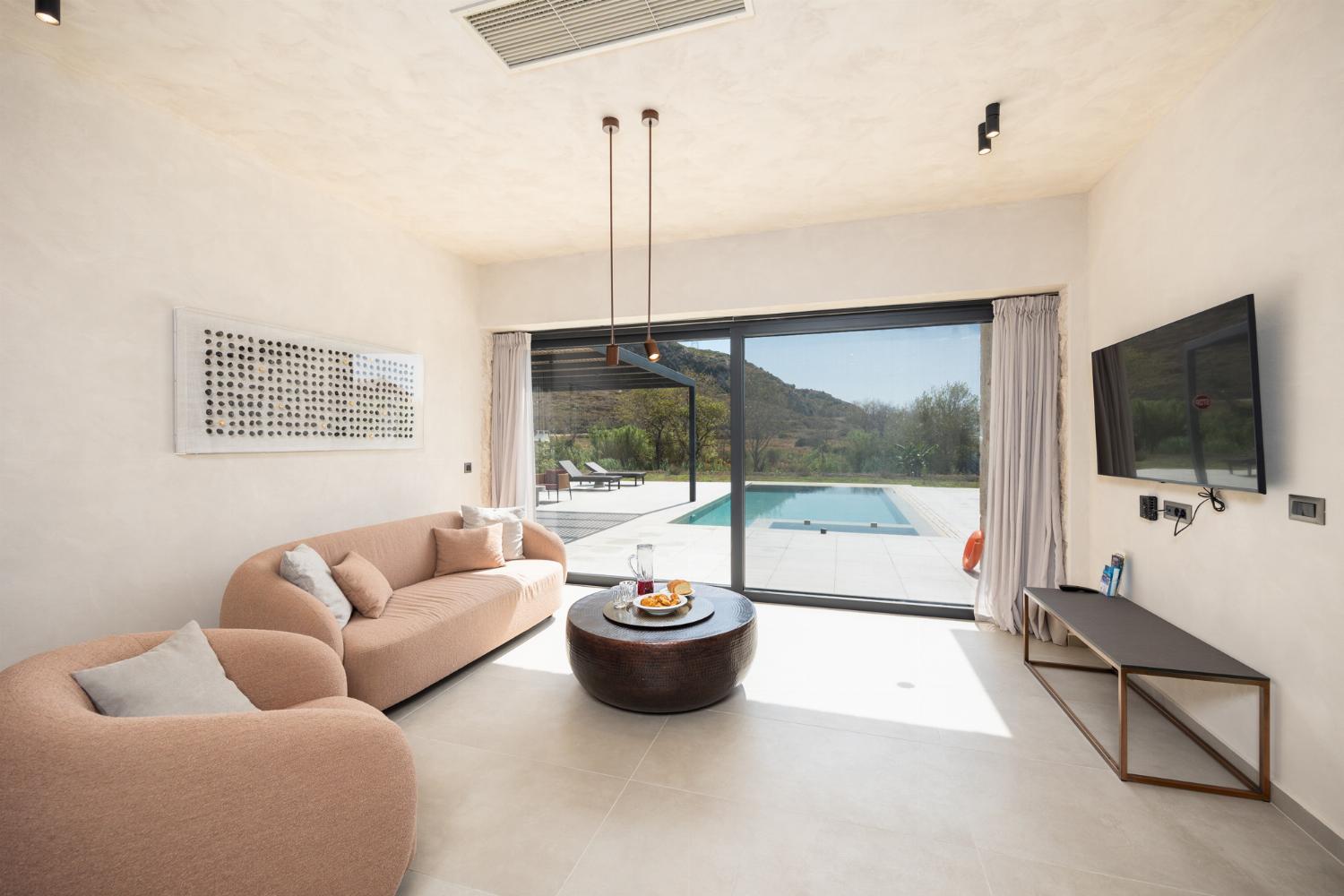 Open-plan living room with sofa, dining area, kitchen, A/C, WiFi internet, and satellite TV