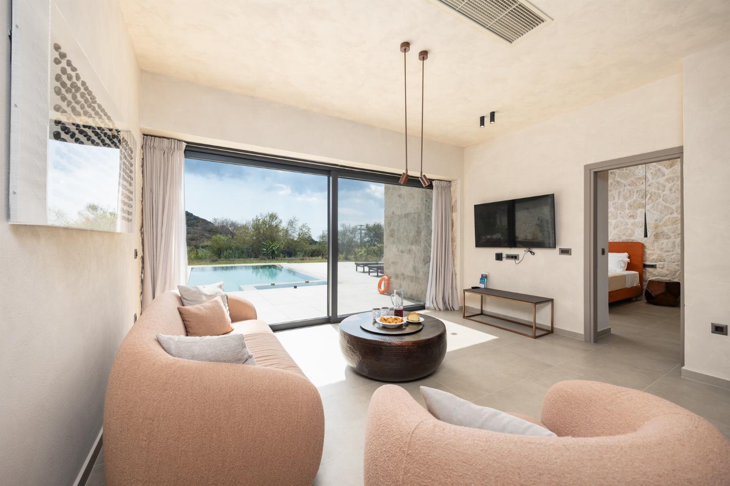 Open-plan living room with sofa, dining area, kitchen, A/C, WiFi internet, and satellite TV