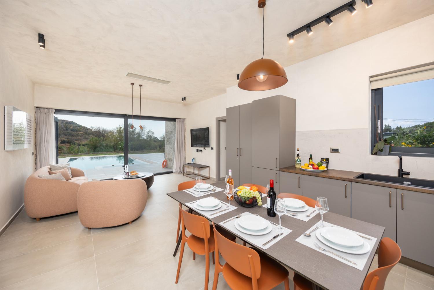Open-plan living room with sofa, dining area, kitchen, A/C, WiFi internet, and satellite TV