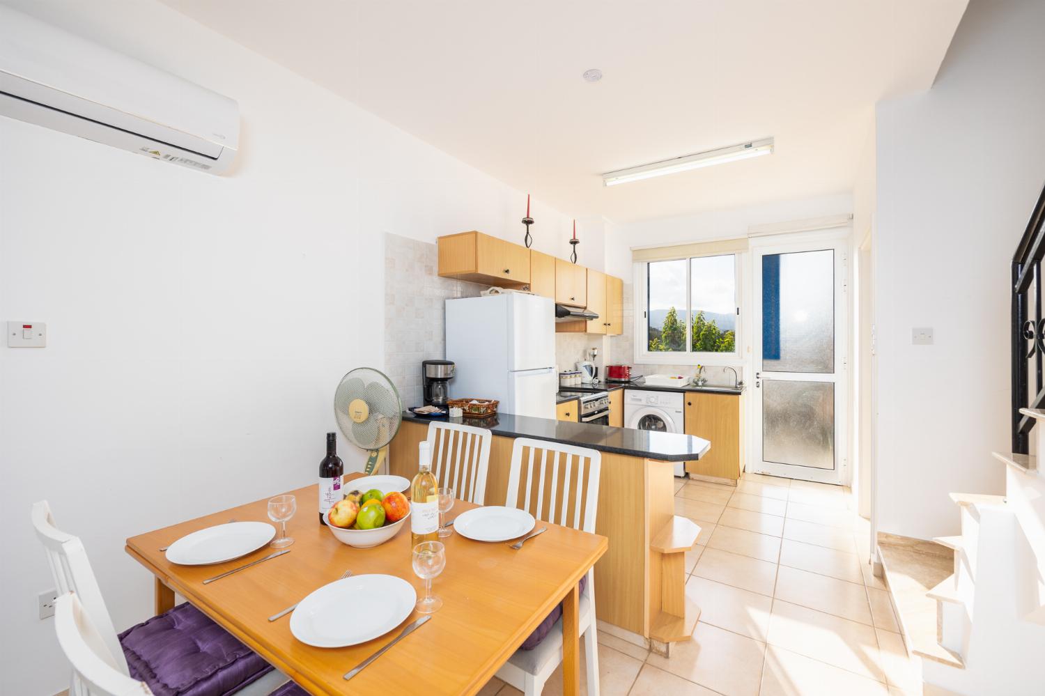 Open-plan living room with sofa, dining area, kitchen, A/C, WiFi internet, and satellite TV