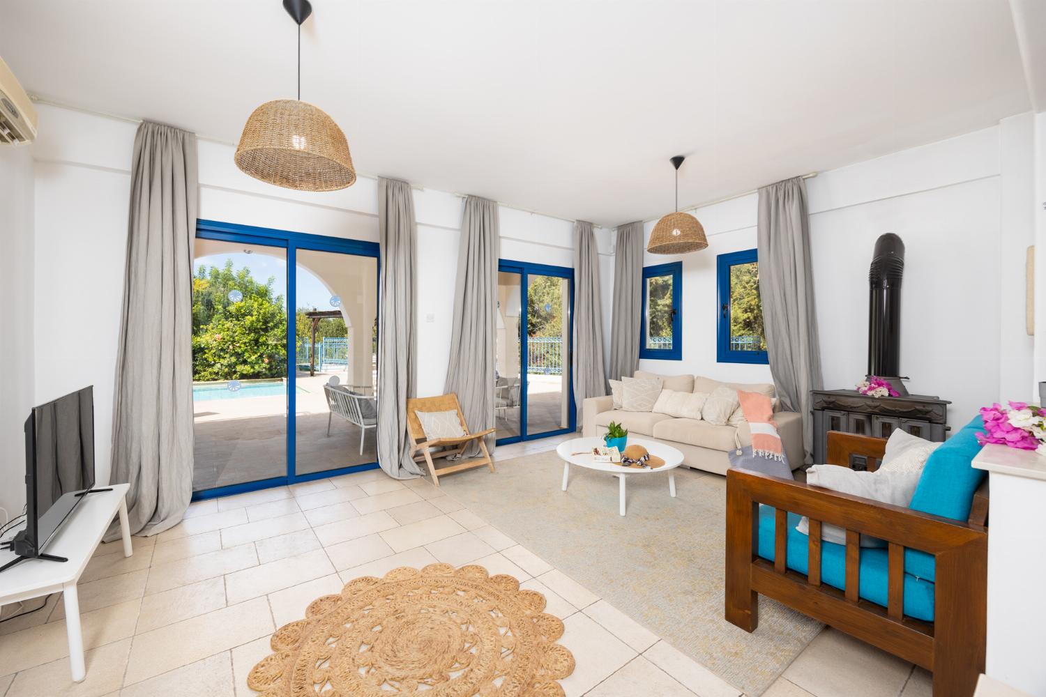 Open-plan living room with sofa, dining area, kitchen, A/C, WiFi internet, and satellite TV