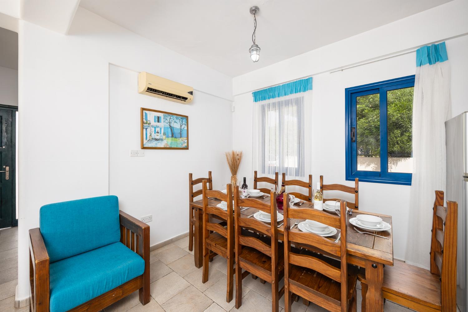 Open-plan living room with sofas, dining area, kitchen, A/C, WiFi internet, and satellite TV