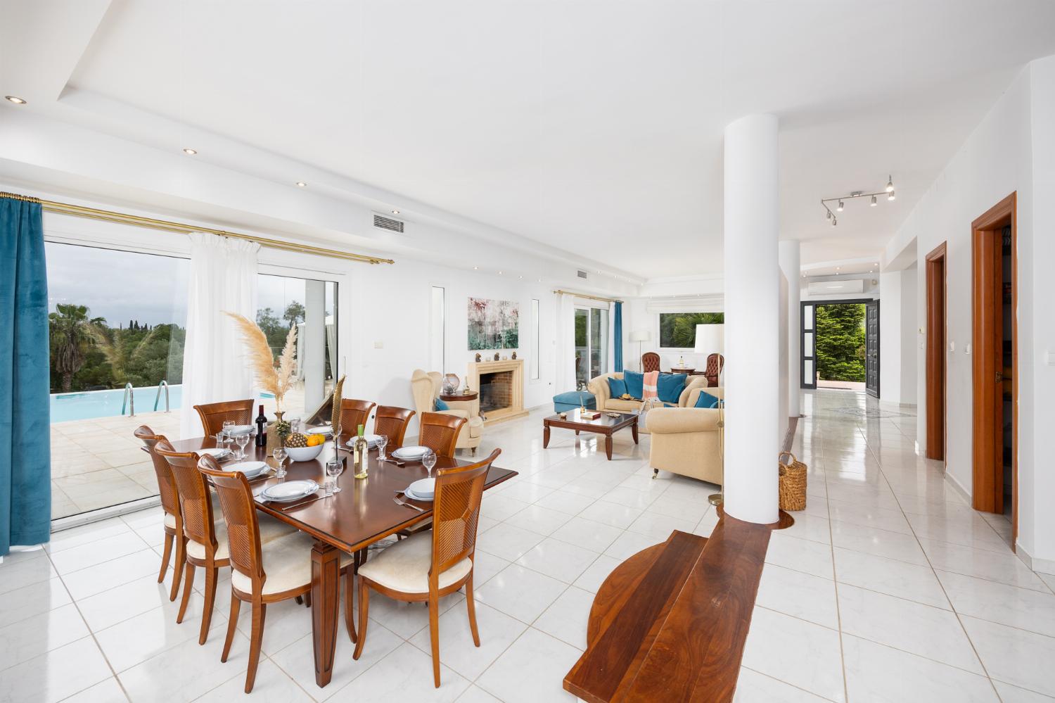 Open-plan living room on first floor with sofas, dining area, kitchen, ornamental fireplace, A/C, and WiFi internet