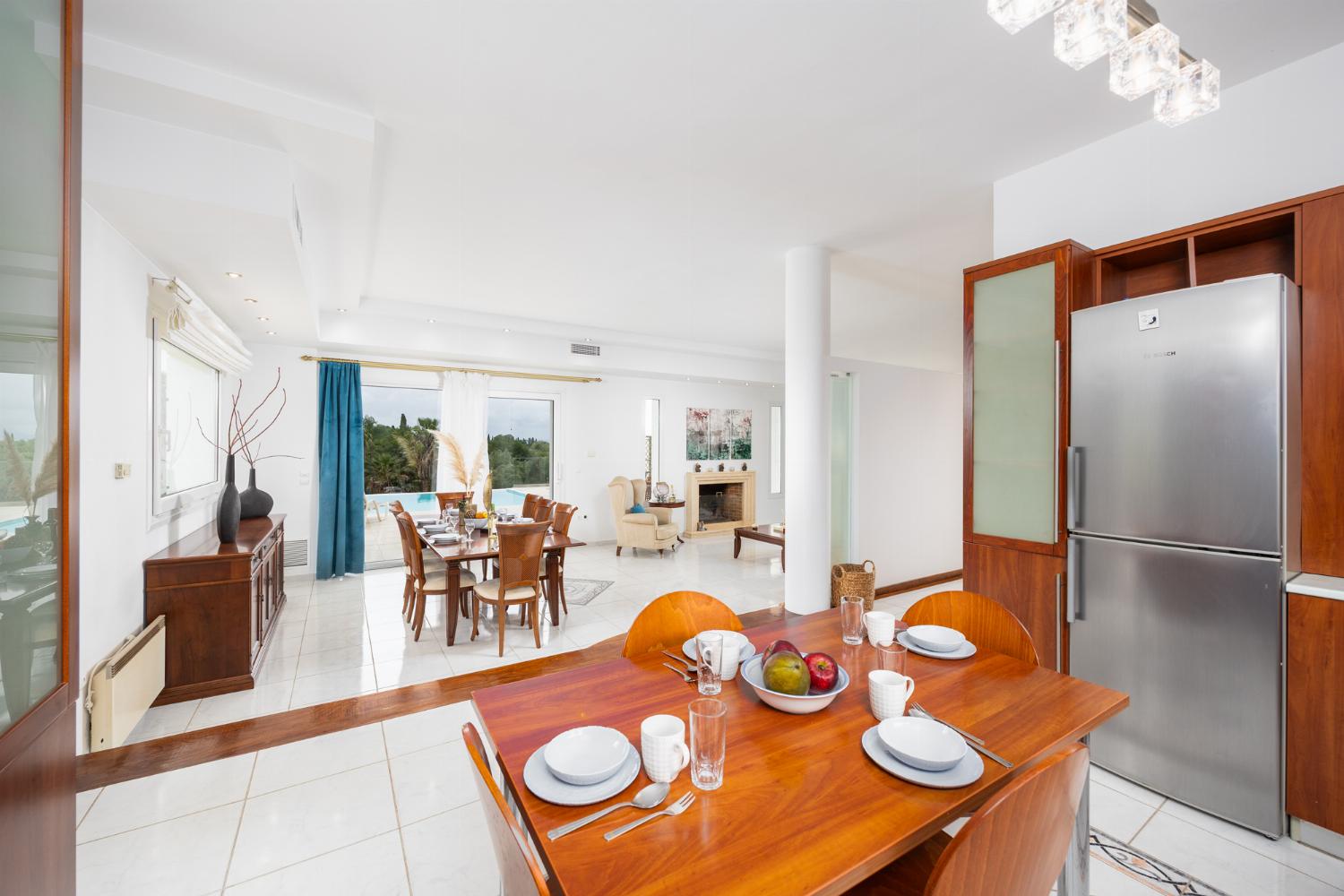 Open-plan living room on first floor with sofas, dining area, kitchen, ornamental fireplace, A/C, and WiFi internet