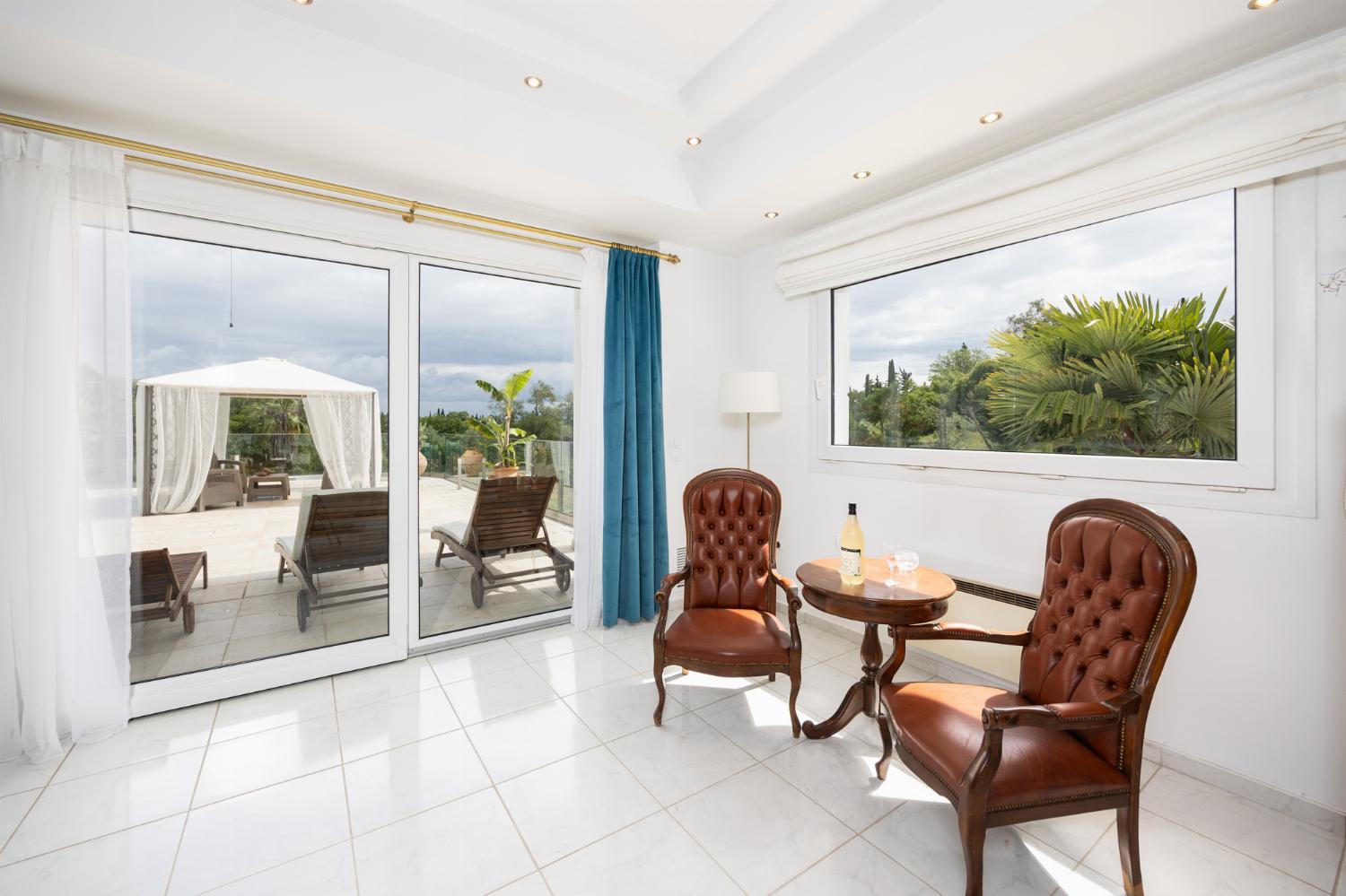 Open-plan living room on first floor with sofas, dining area, kitchen, ornamental fireplace, A/C, and WiFi internet