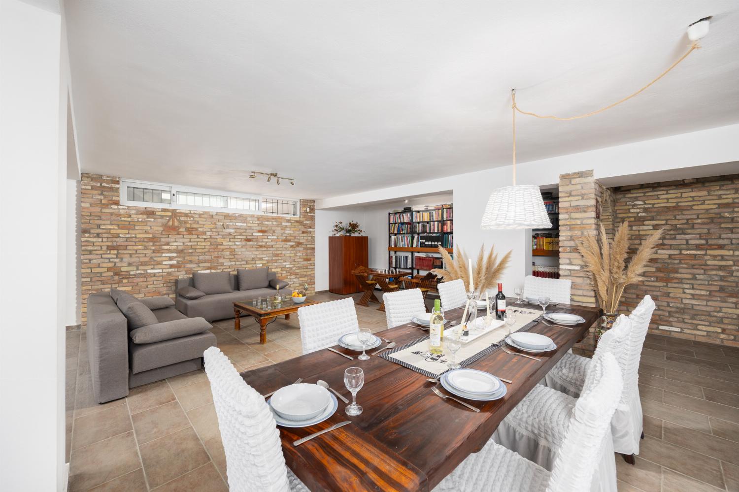 Open-plan living room on ground floor with sofas, dining area, bar area, ornamental fireplace, gym area, WiFi internet, and satellite TV