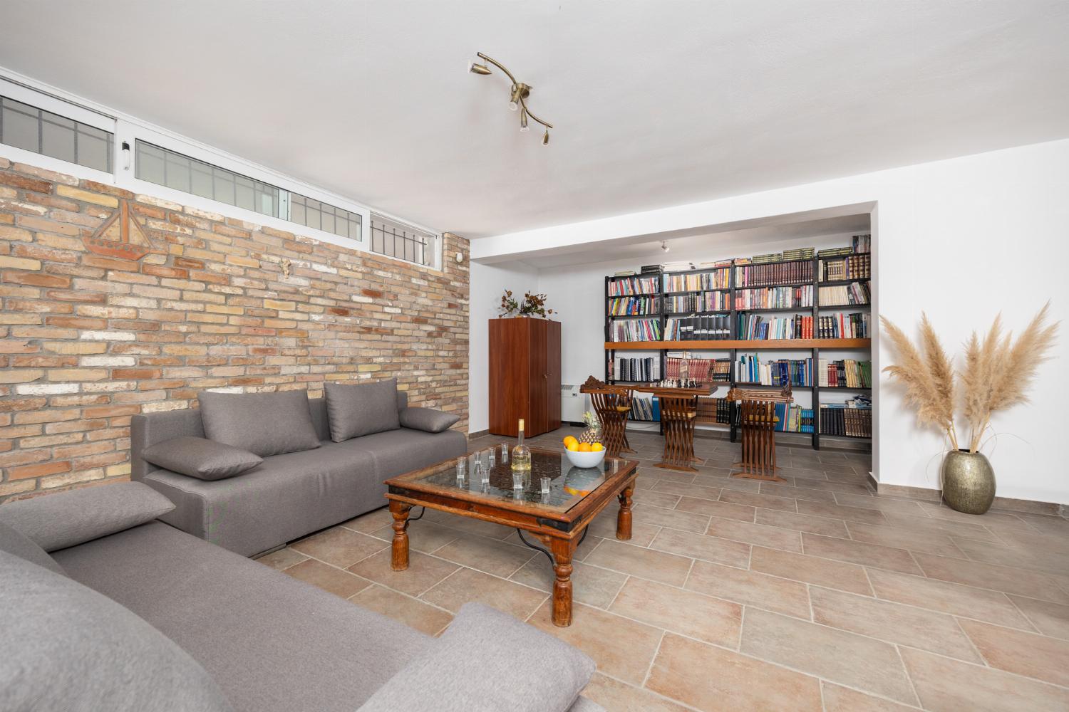 Open-plan living room on ground floor with sofas, dining area, bar area, ornamental fireplace, gym area, WiFi internet, and satellite TV