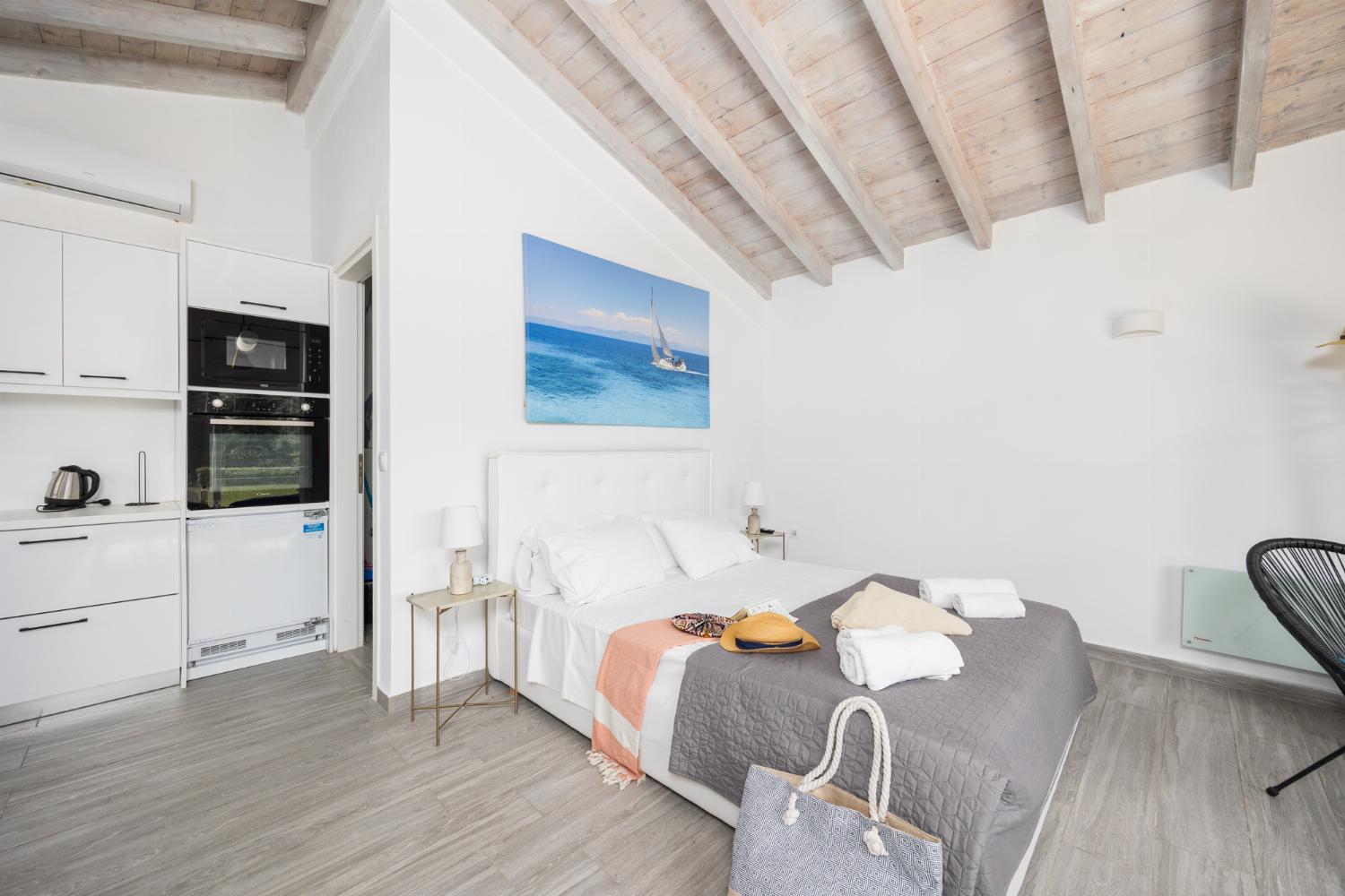 Studio apartment in annex with double bed, living area, dining area, kitchen, en suite bathroom, A/C, WiFi internet, and satellite TV