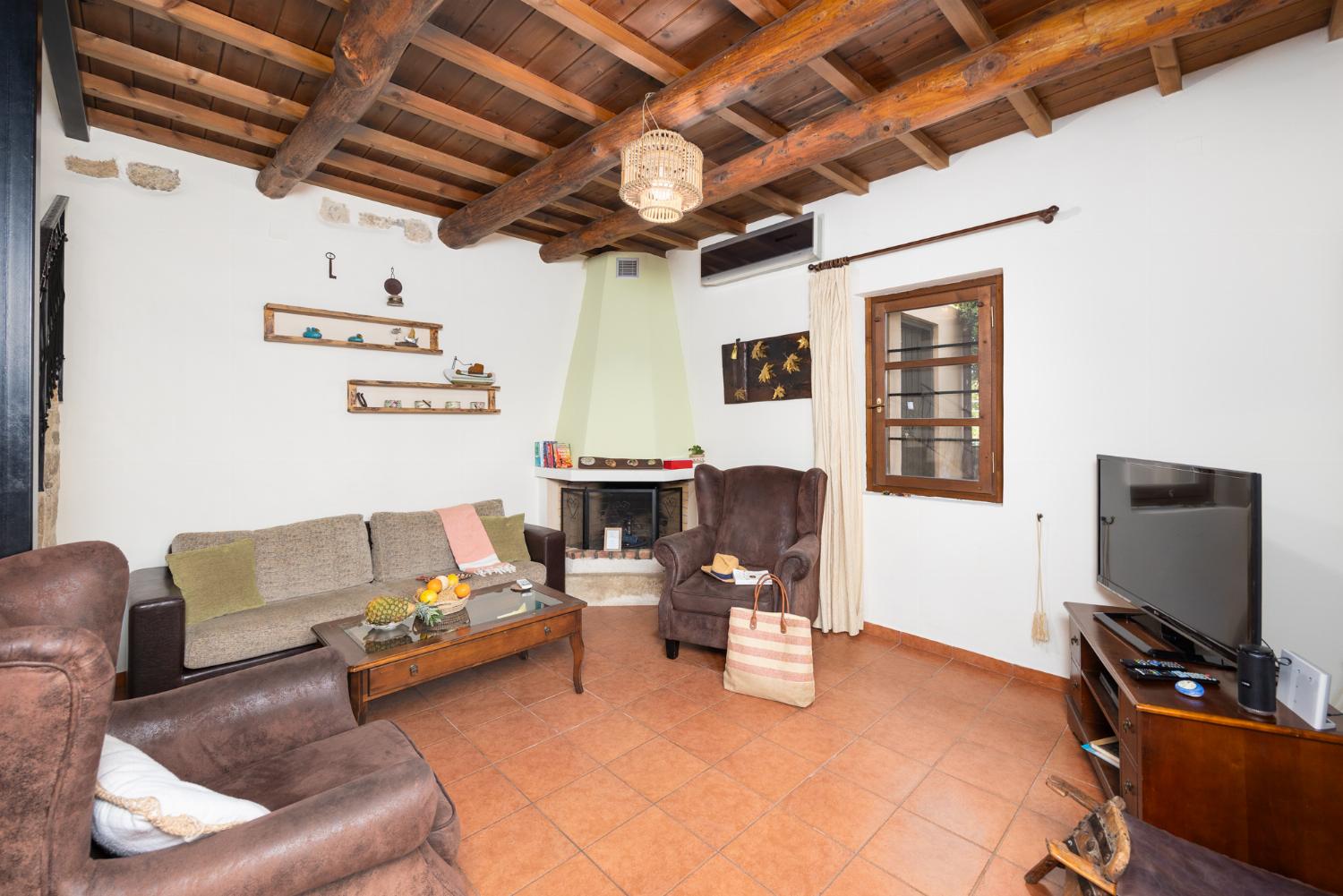 Living room with sofa, ornamental fireplace, A/C, WiFi internet, and satellite TV