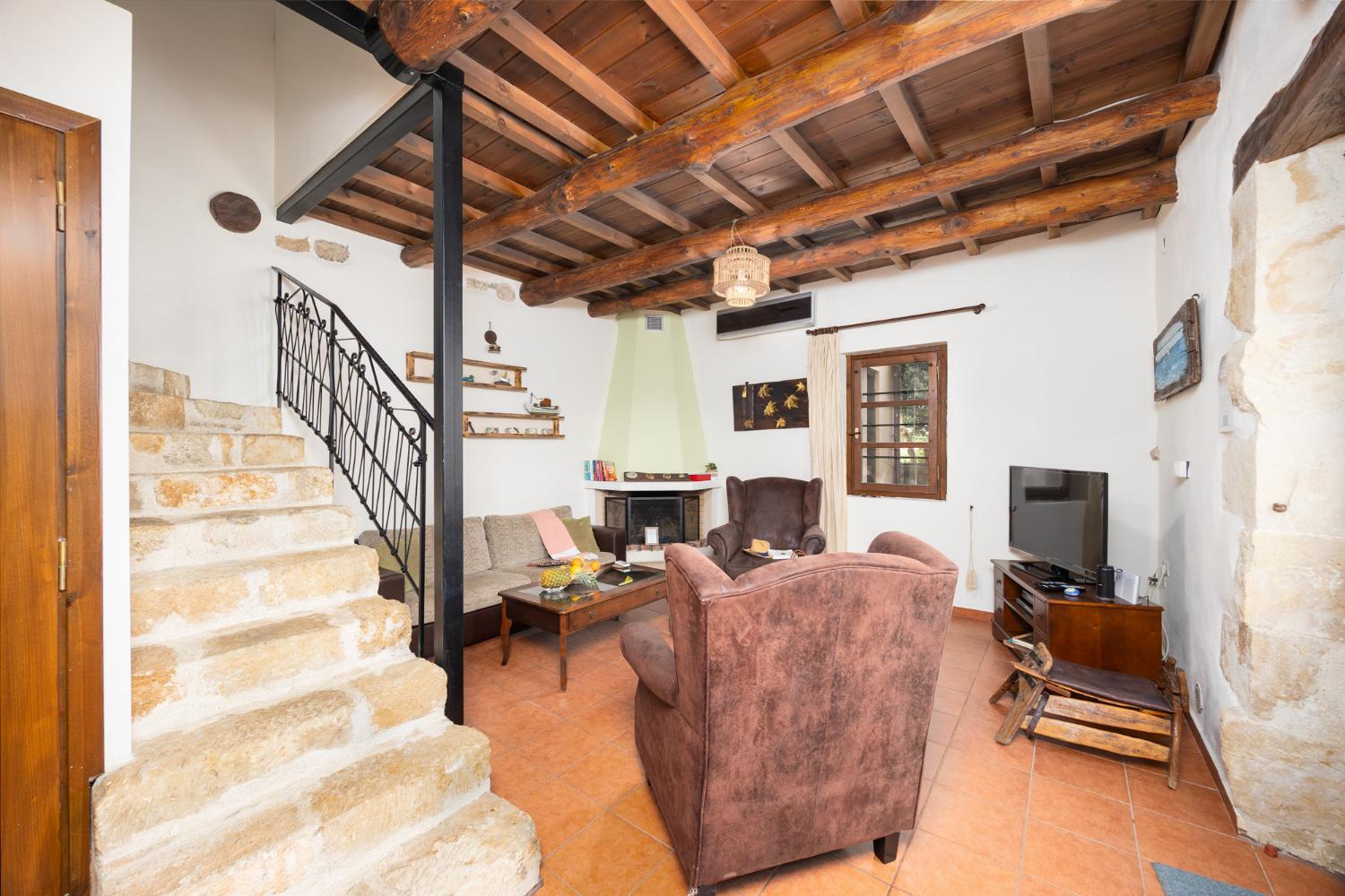 Living room with sofa, ornamental fireplace, A/C, WiFi internet, and satellite TV