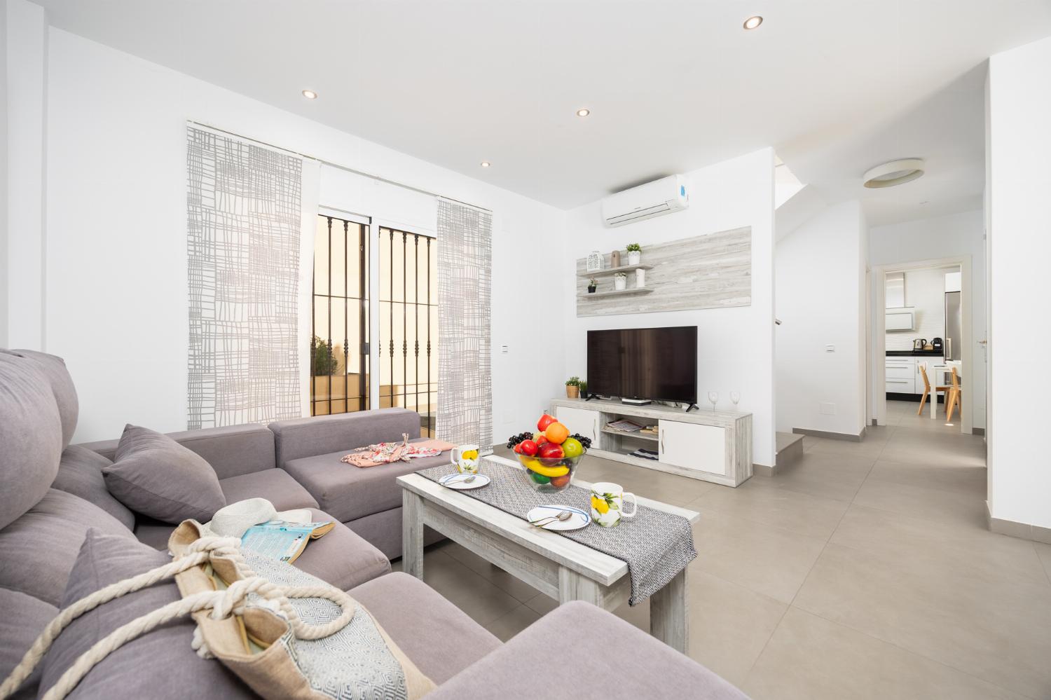 Living room with sofa, dining area, A/C, WiFi internet, and satellite TV