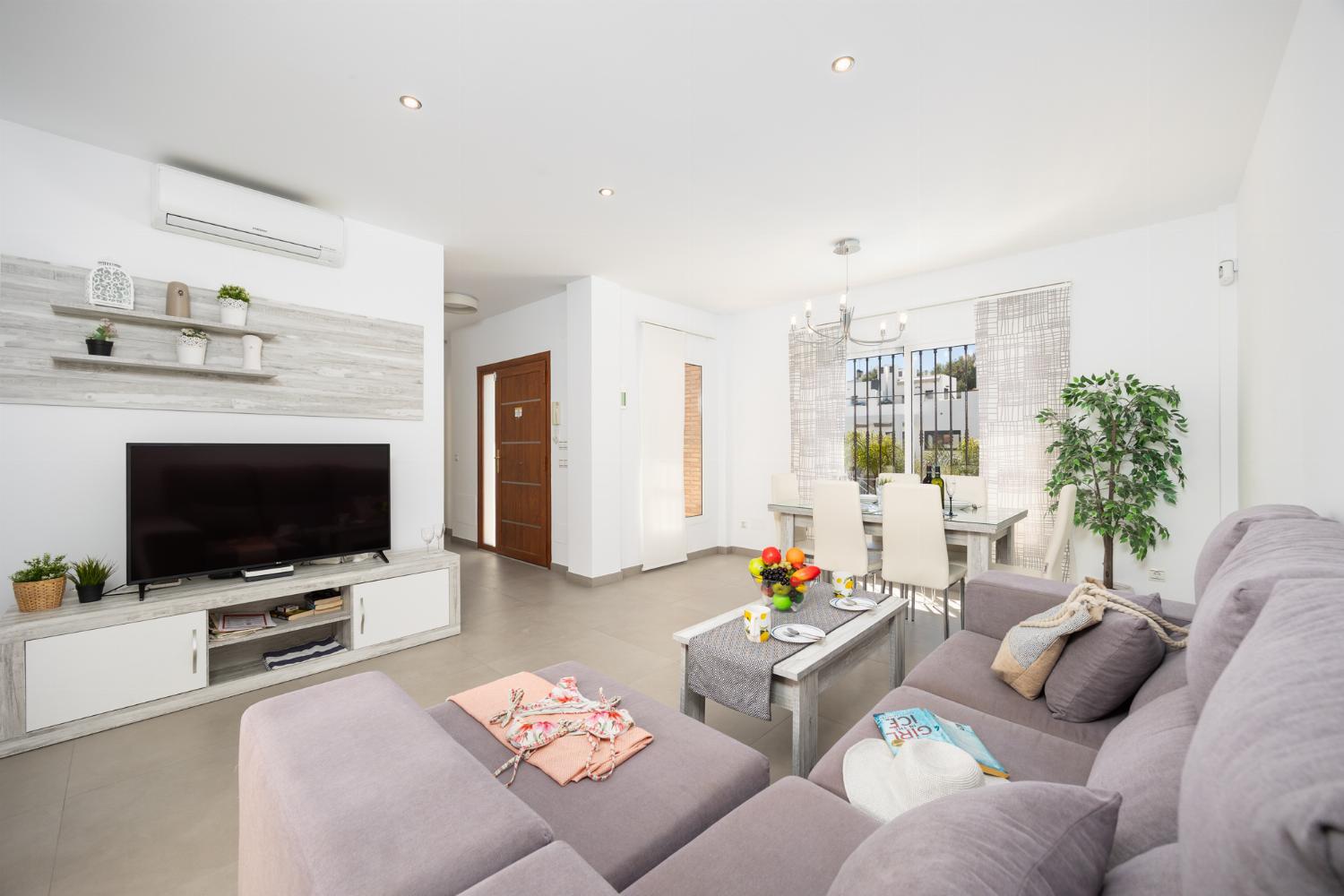 Living room with sofa, dining area, A/C, WiFi internet, and satellite TV