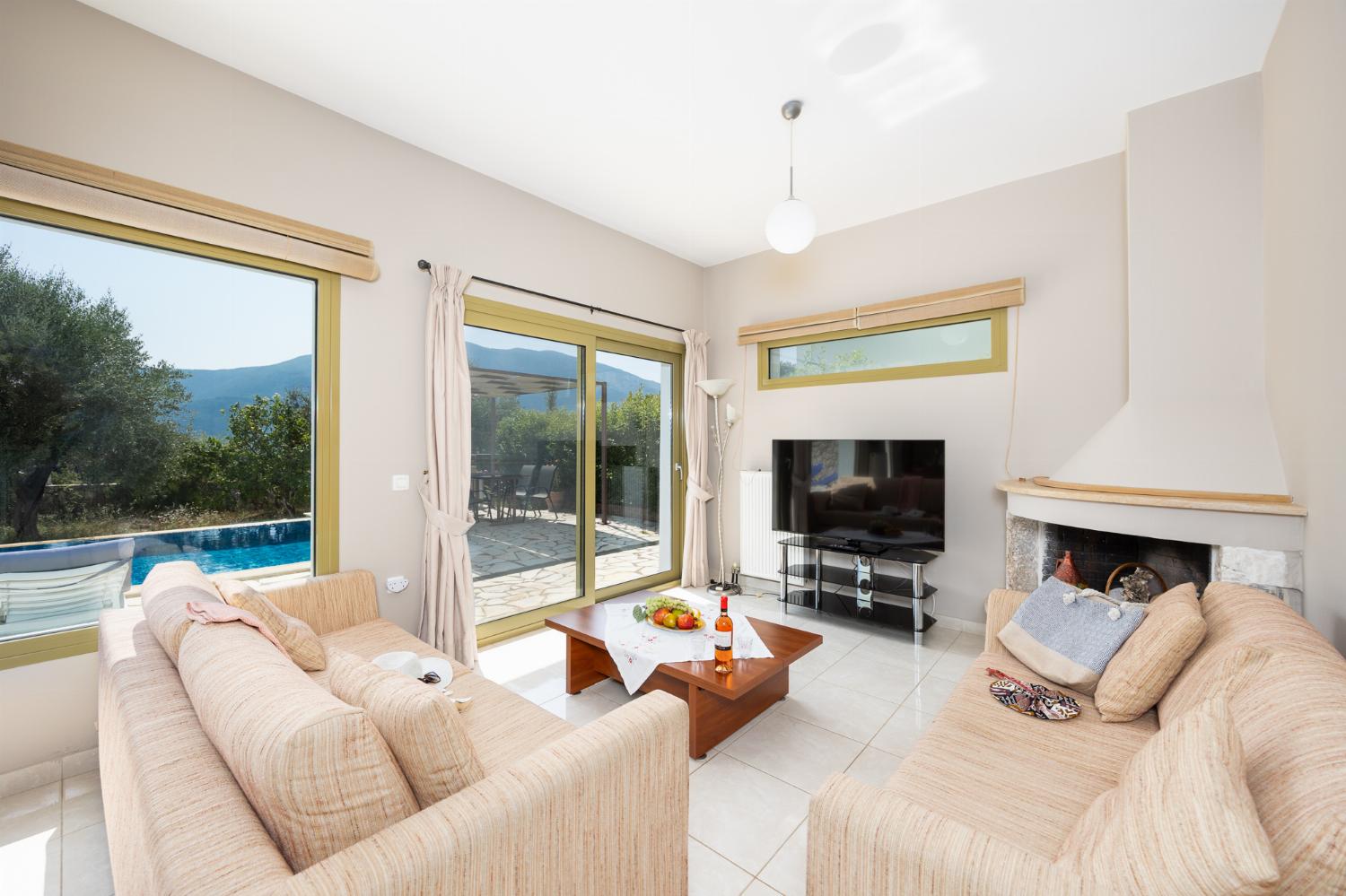 Living room with sofas, dining area, ornamental fireplace, A/C, WiFi internet, and satellite TV