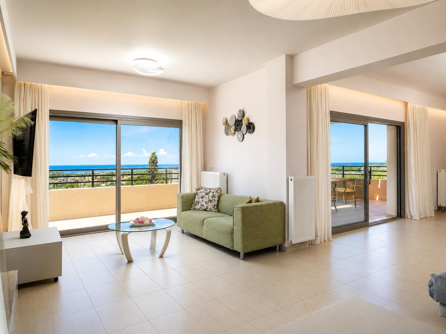 Open-plan living room with sofas, dining area, kitchen, ornamental fireplace, A/C, WiFi internet, and satellite TV