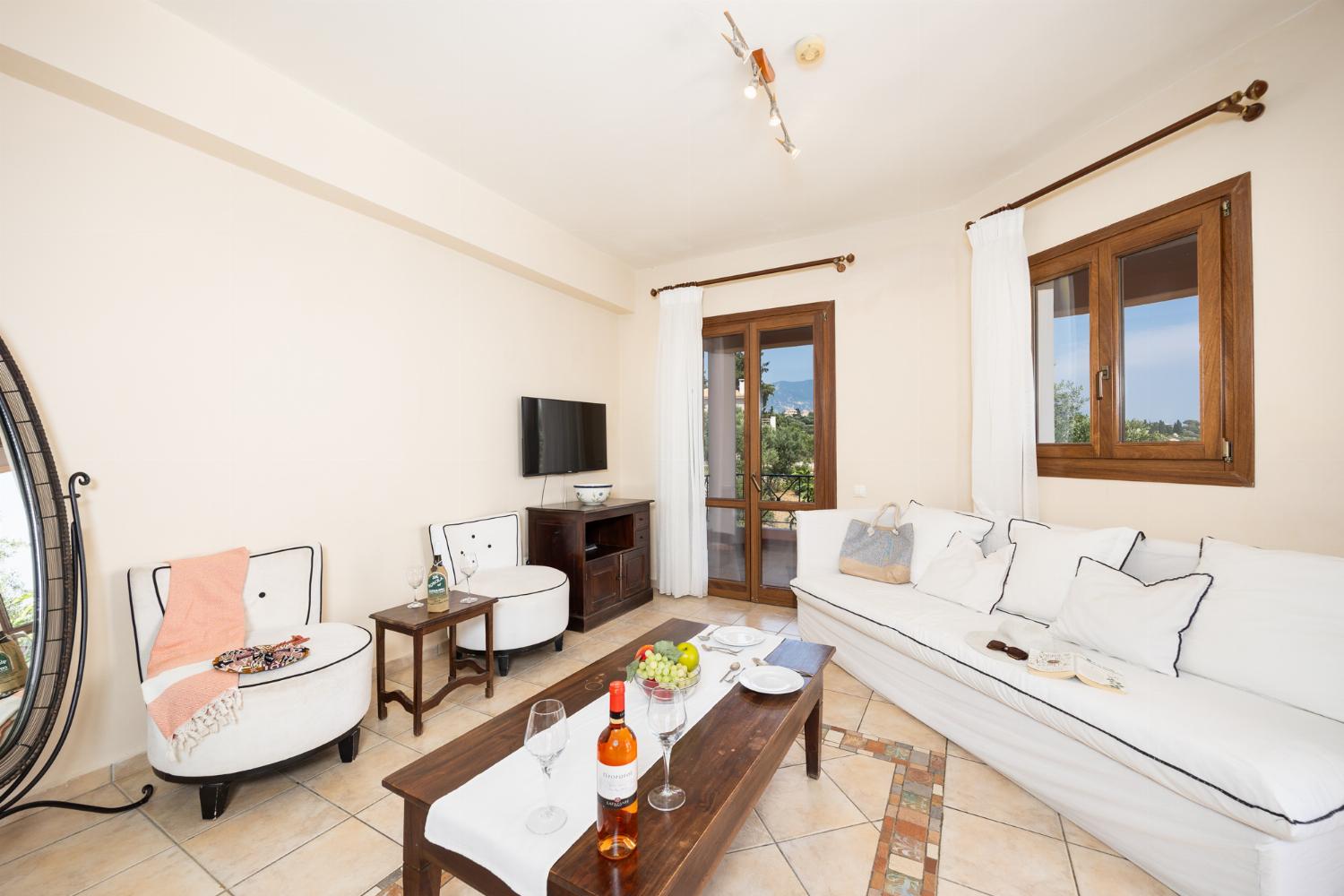 Open-plan living room with sofa, dining area, kitchen, ornamental fireplace, A/C, WiFi internet, and satellite TV