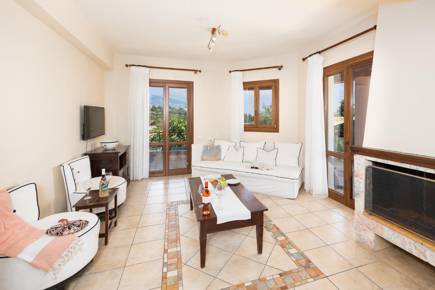 Open-plan living room with sofa, dining area, kitchen, ornamental fireplace, A/C, WiFi internet, and satellite TV