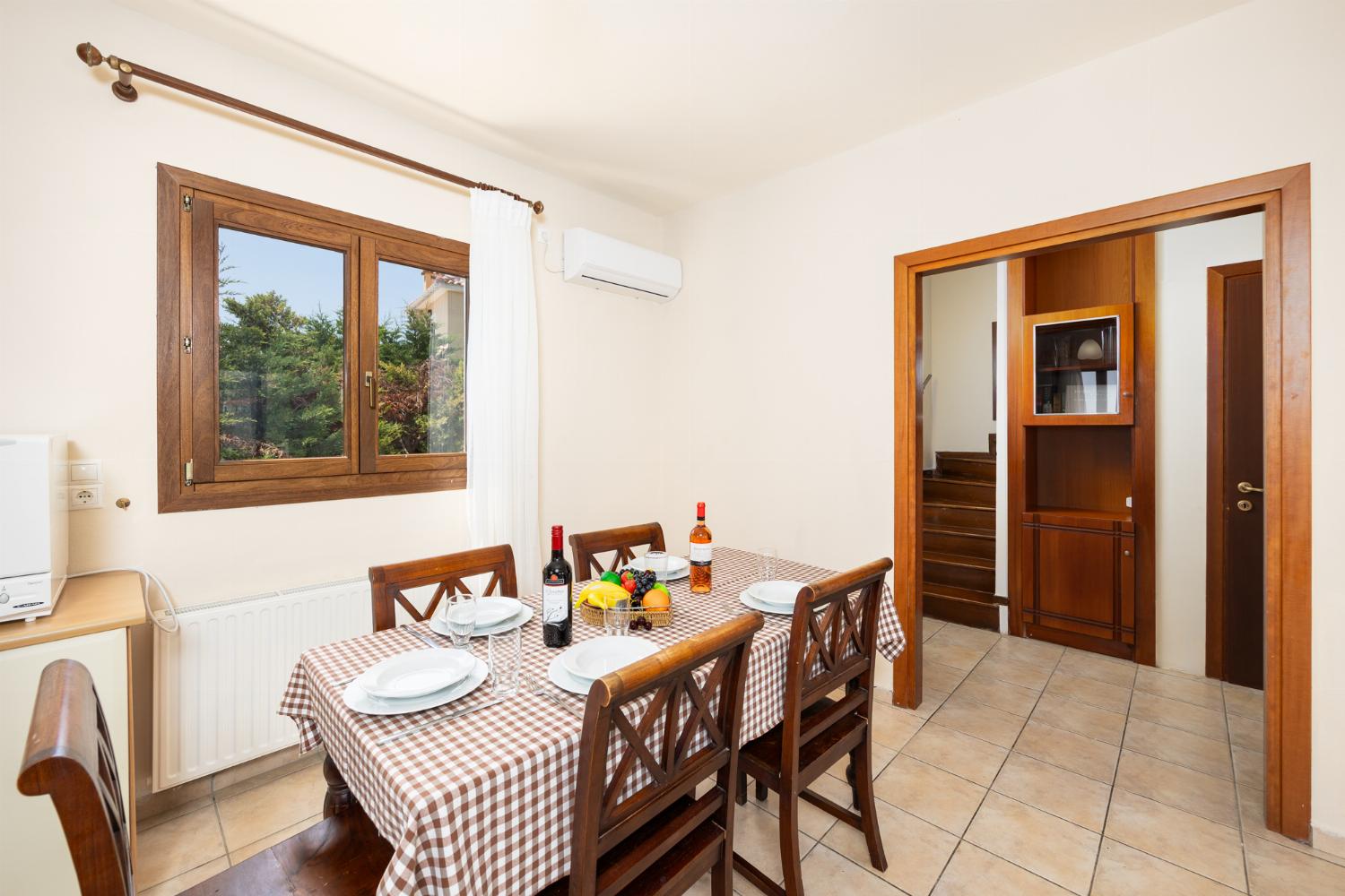 Open-plan living room with sofa, dining area, kitchen, ornamental fireplace, A/C, WiFi internet, and satellite TV