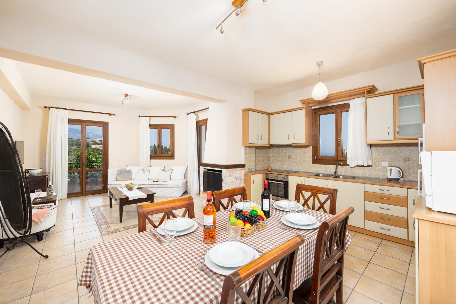 Open-plan living room with sofa, dining area, kitchen, ornamental fireplace, A/C, WiFi internet, and satellite TV