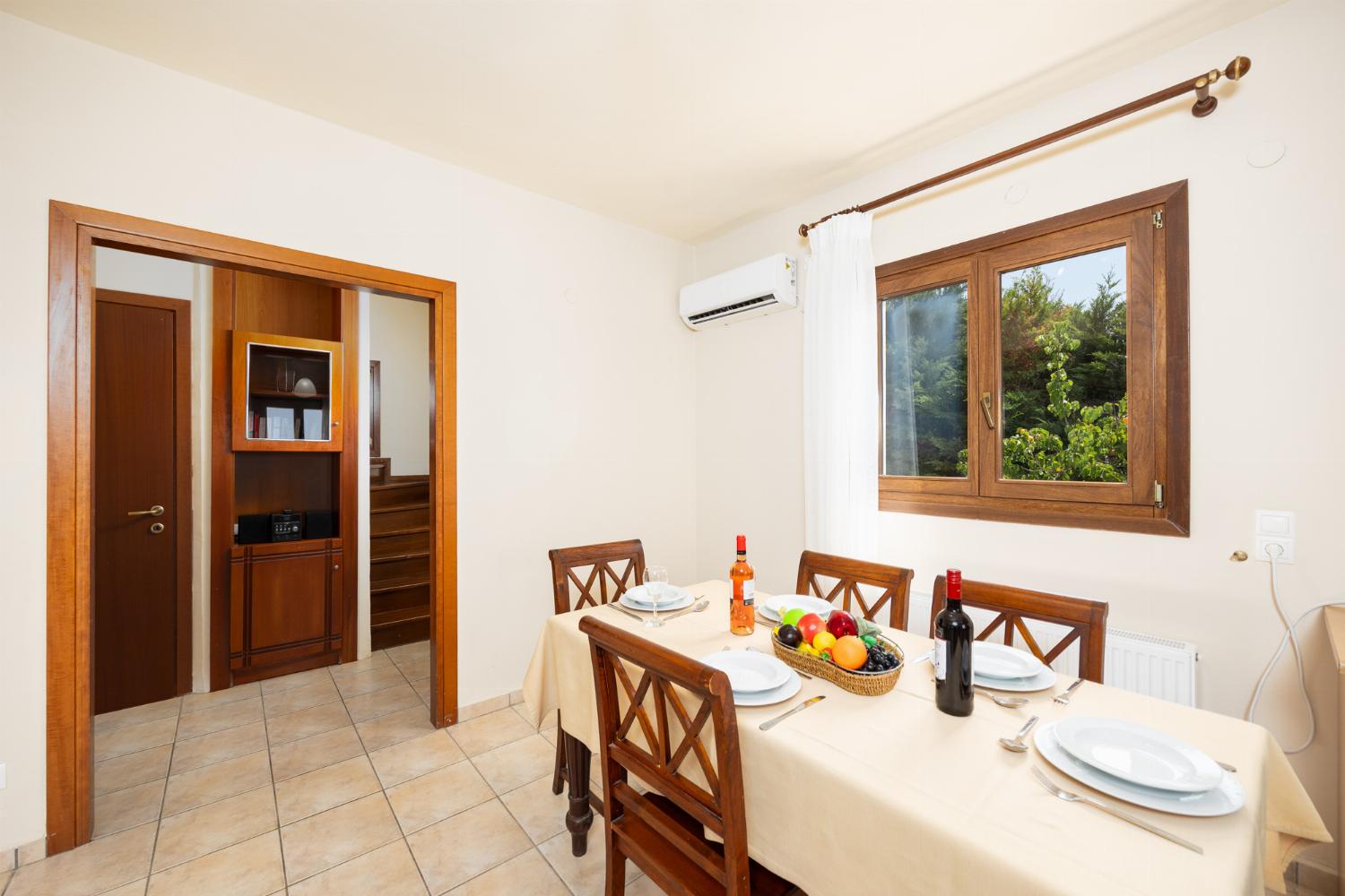 Open-plan living room with sofas, dining area, kitchen, ornamental fireplace, A/C, WiFi internet, and satellite TV
