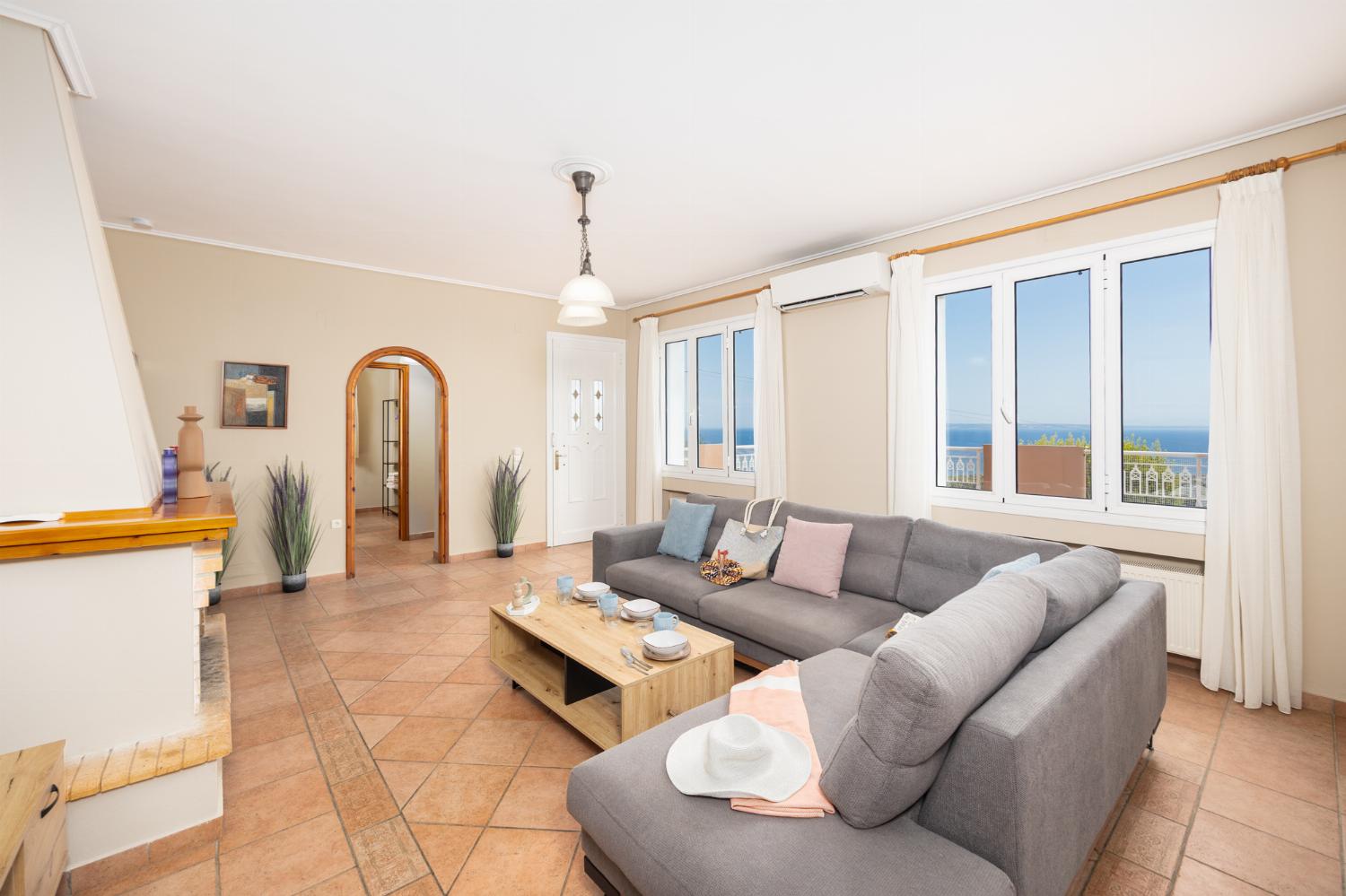 Living room with sofa, ornamental fireplace, A/C, WiFi internet, satellite TV, and sea views