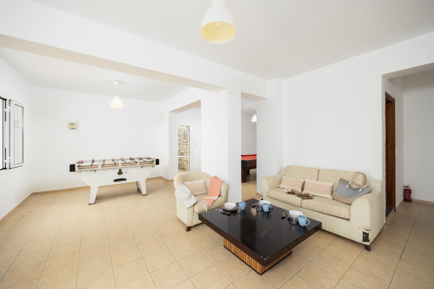 Games room with living area, pool table, foosball table, and table tennis