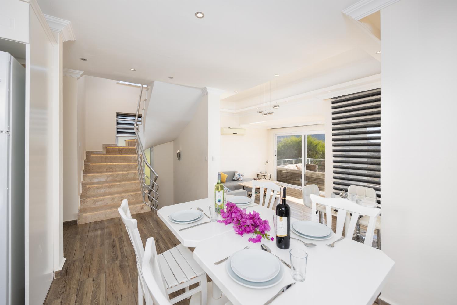 Open-plan living room with sofa, dining area, kitchen, A/C, WiFi internet, and satellite TV