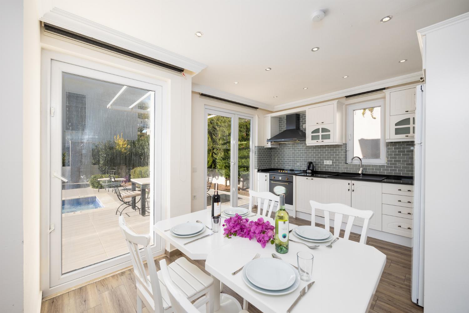 Open-plan living room with sofa, dining area, kitchen, A/C, WiFi internet, and satellite TV